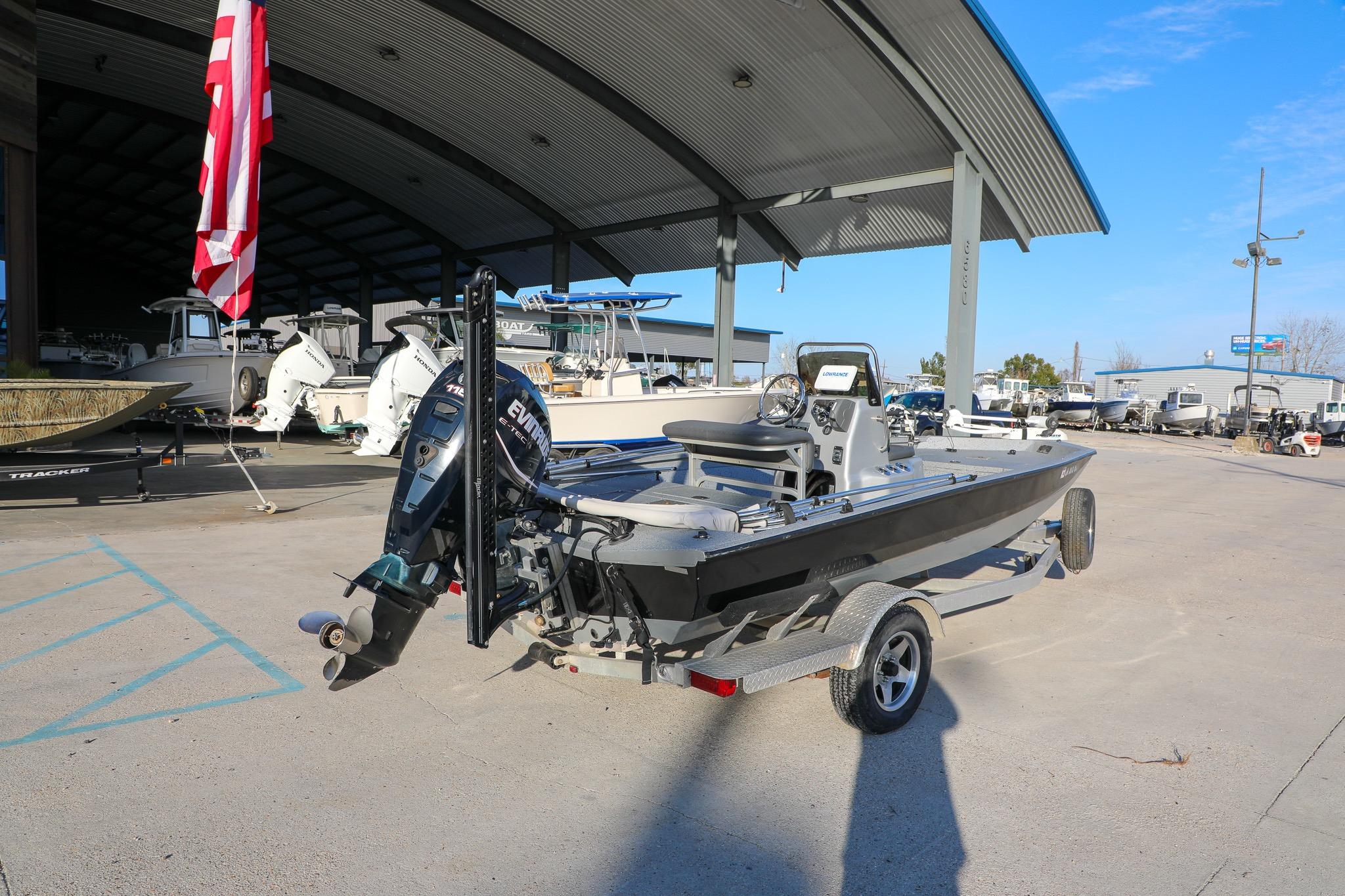 2019 Express 18 boat on trailer at marina, under large canopy.