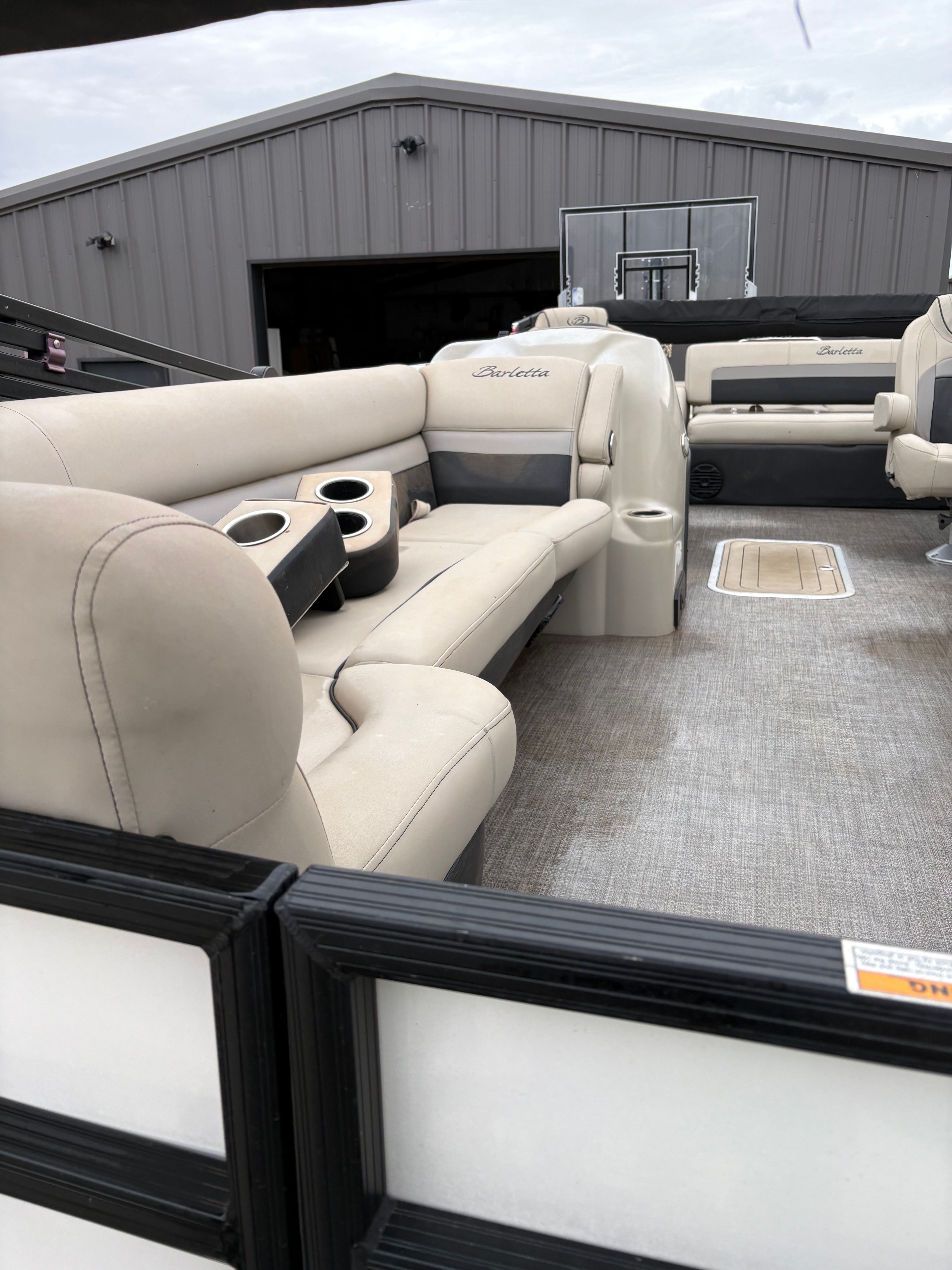 The image shows the interior of a 2021 Barletta C24UC boat with beige seating.