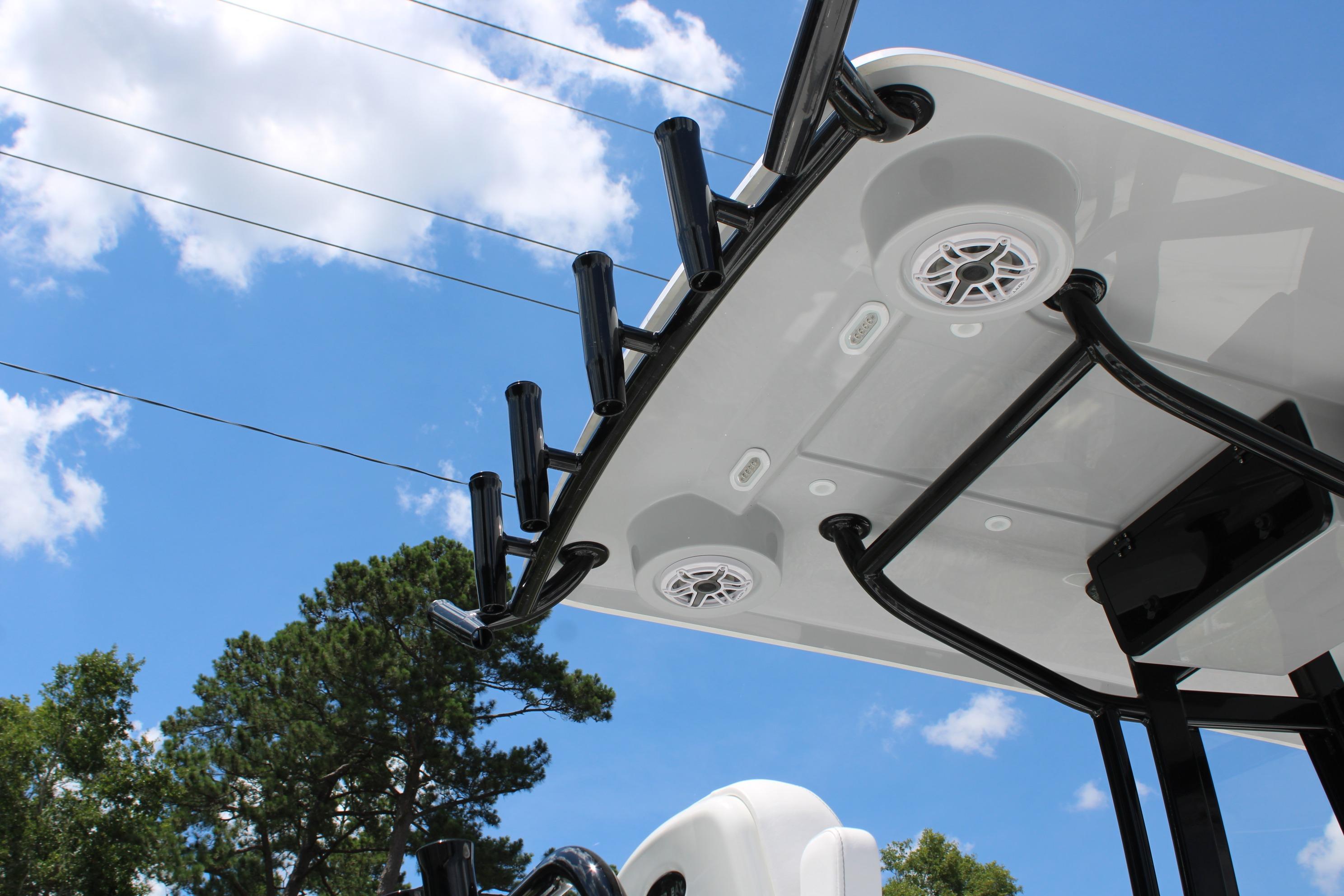 T-top of 2027 Blazer Bay Makaira 2800 boat with rod holders and speakers against blue sky.