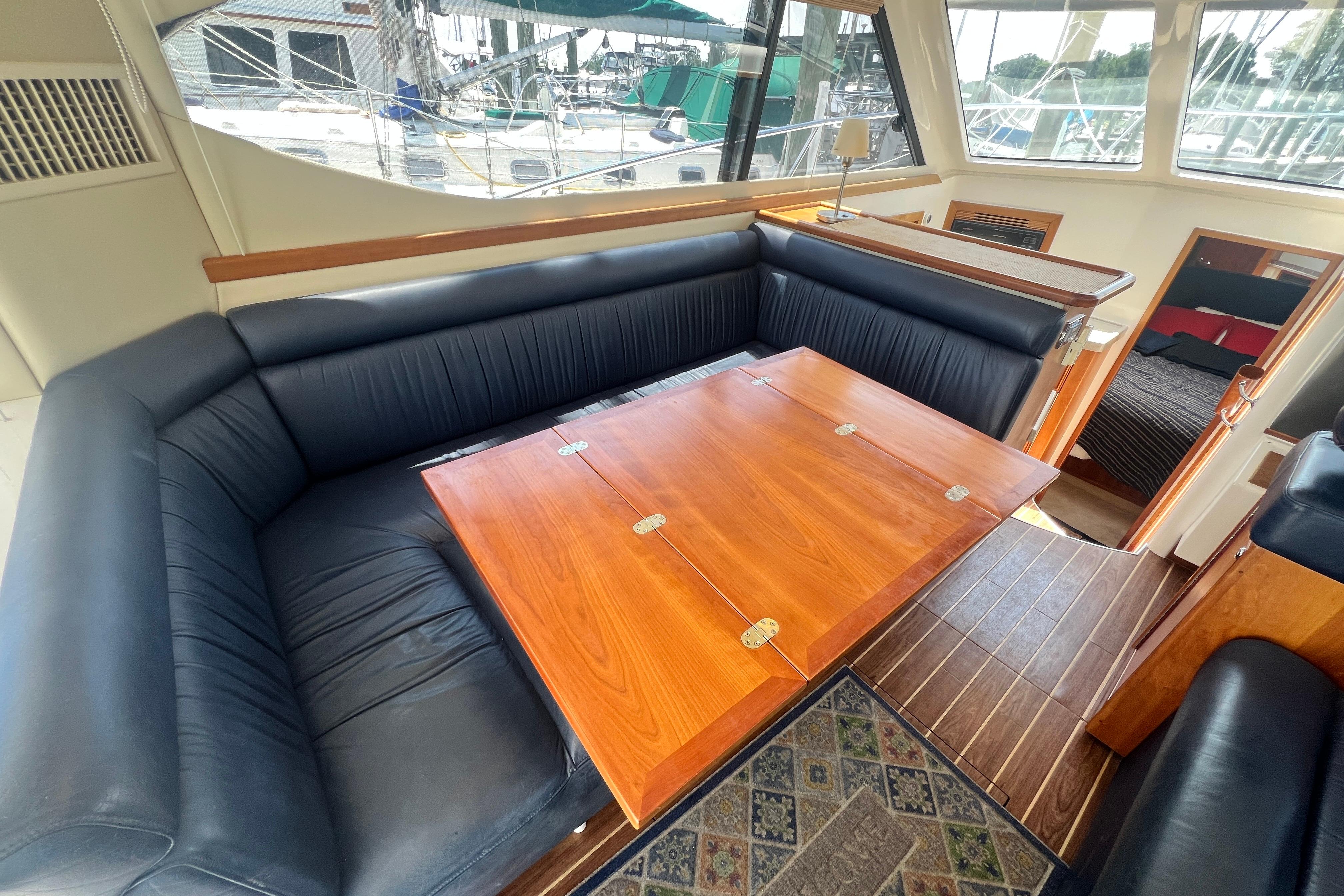 Luxurious interior of 2007 Riviera 33 Flybridge yacht with elegant seating and wooden table.