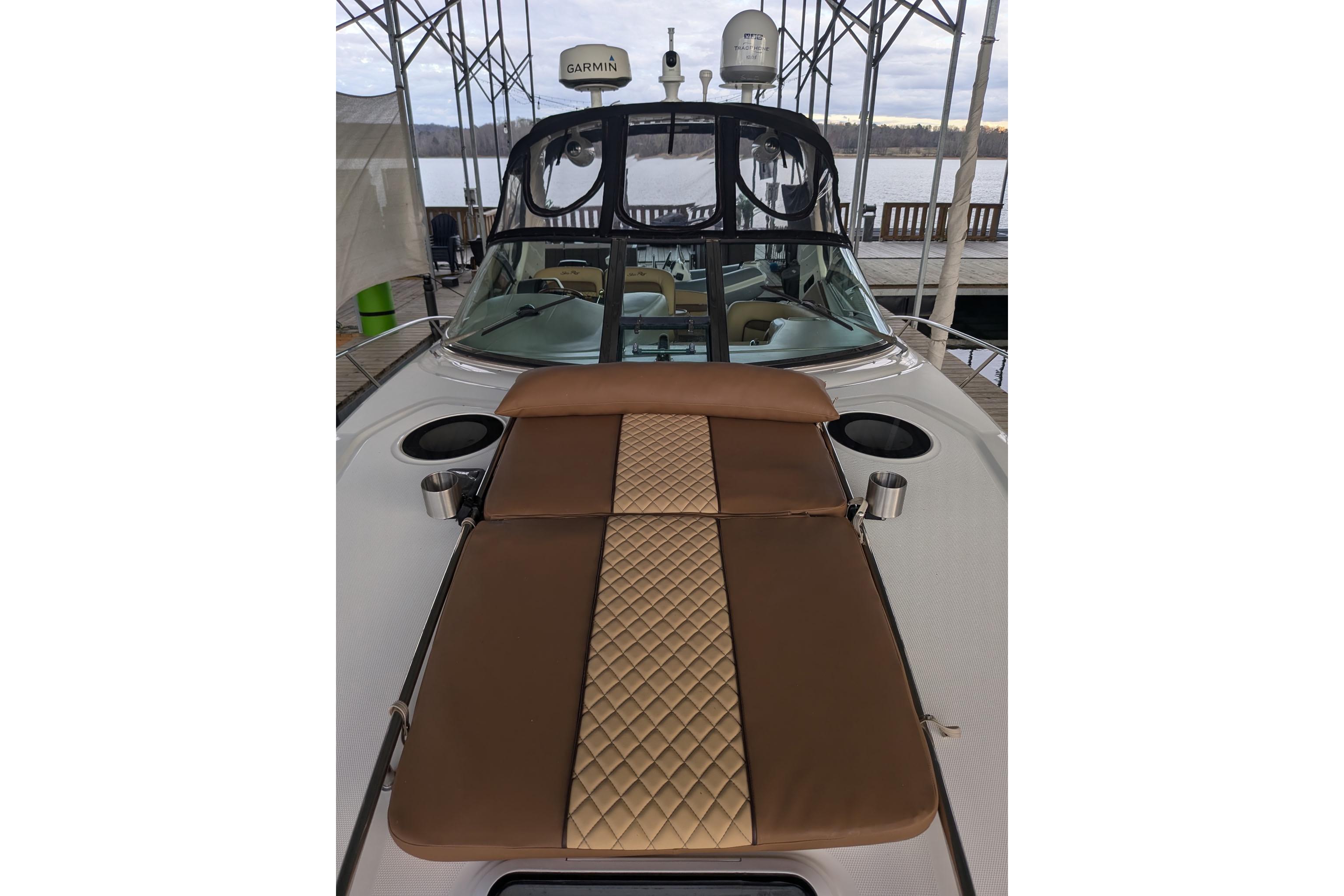 2002 Sea Ray Sundancer 320 with brown cushioned deck, docked by the water.