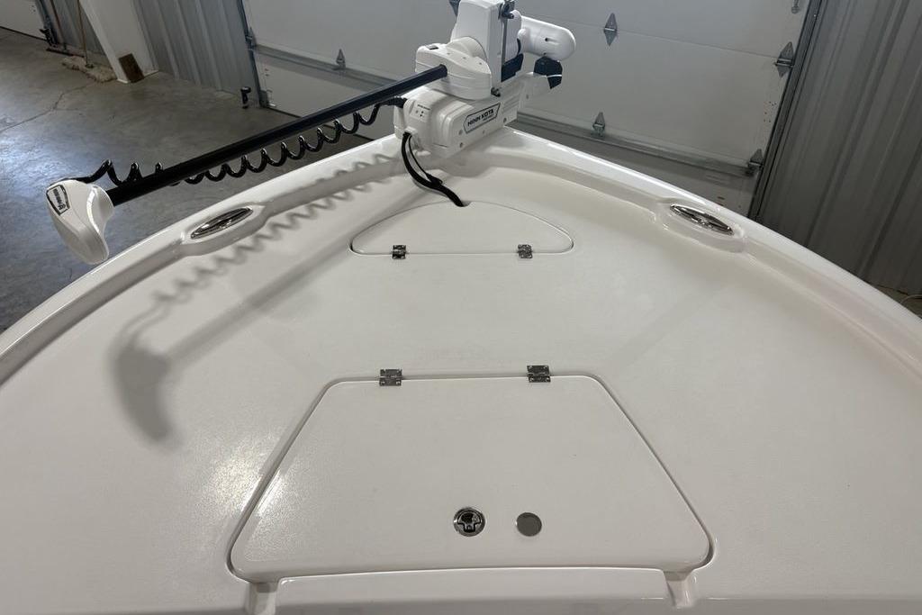 Bow of 2026 Tidewater 2210 Carolina Bay boat with trolling motor in garage.