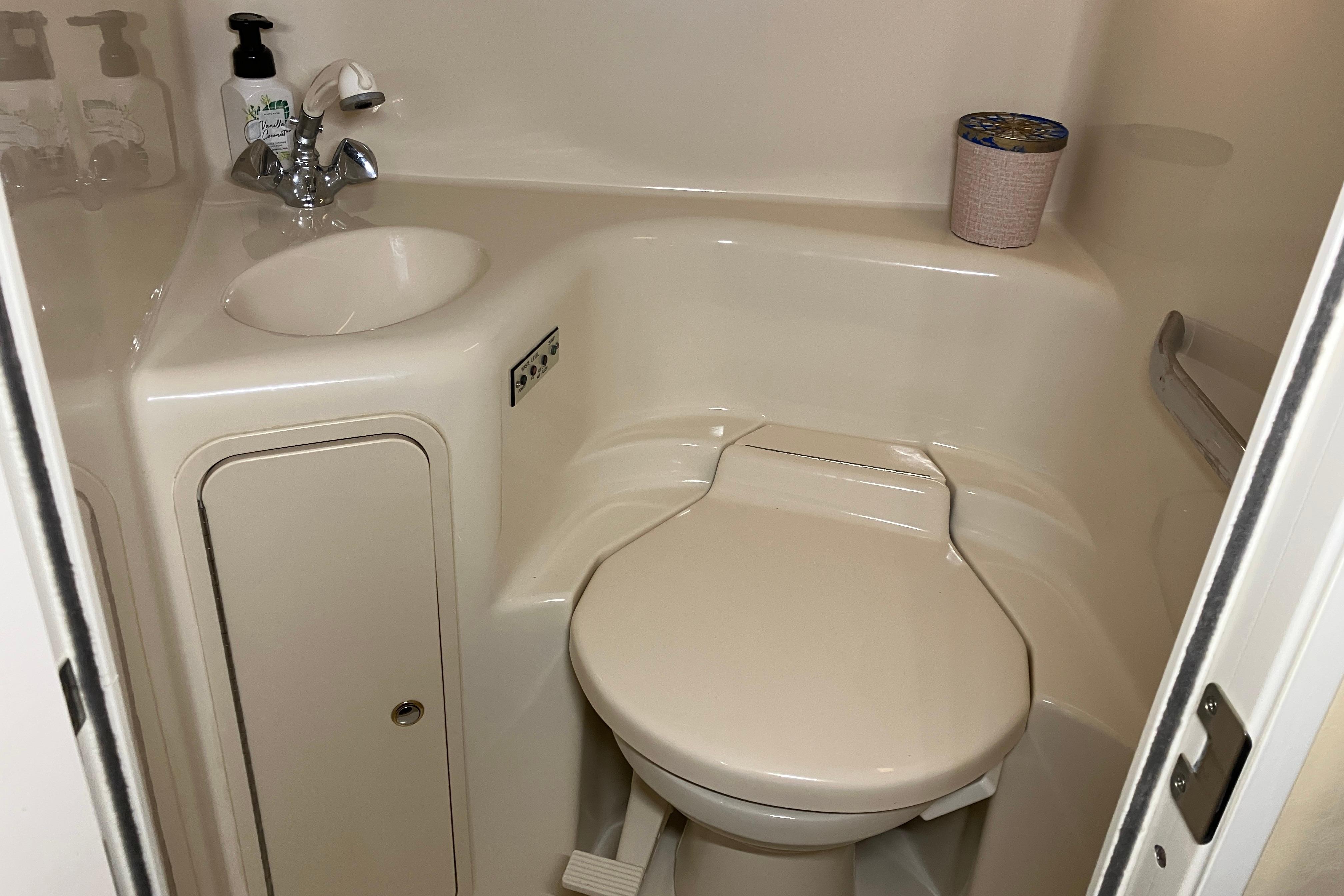 Compact bathroom in 2002 Sea Ray 410 Sundancer yacht, featuring sink and toilet.