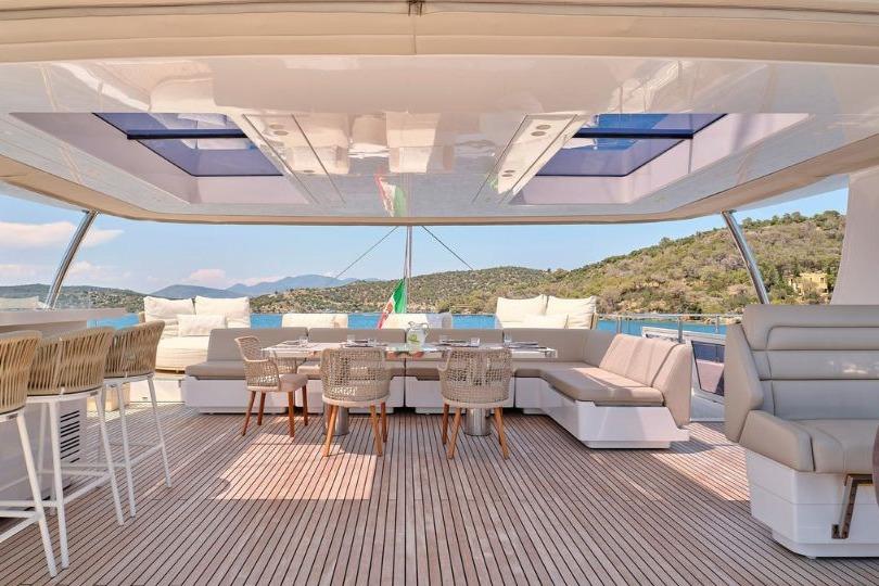 Luxurious Sunreef 80 yacht deck with elegant seating, dining area, and scenic ocean view.