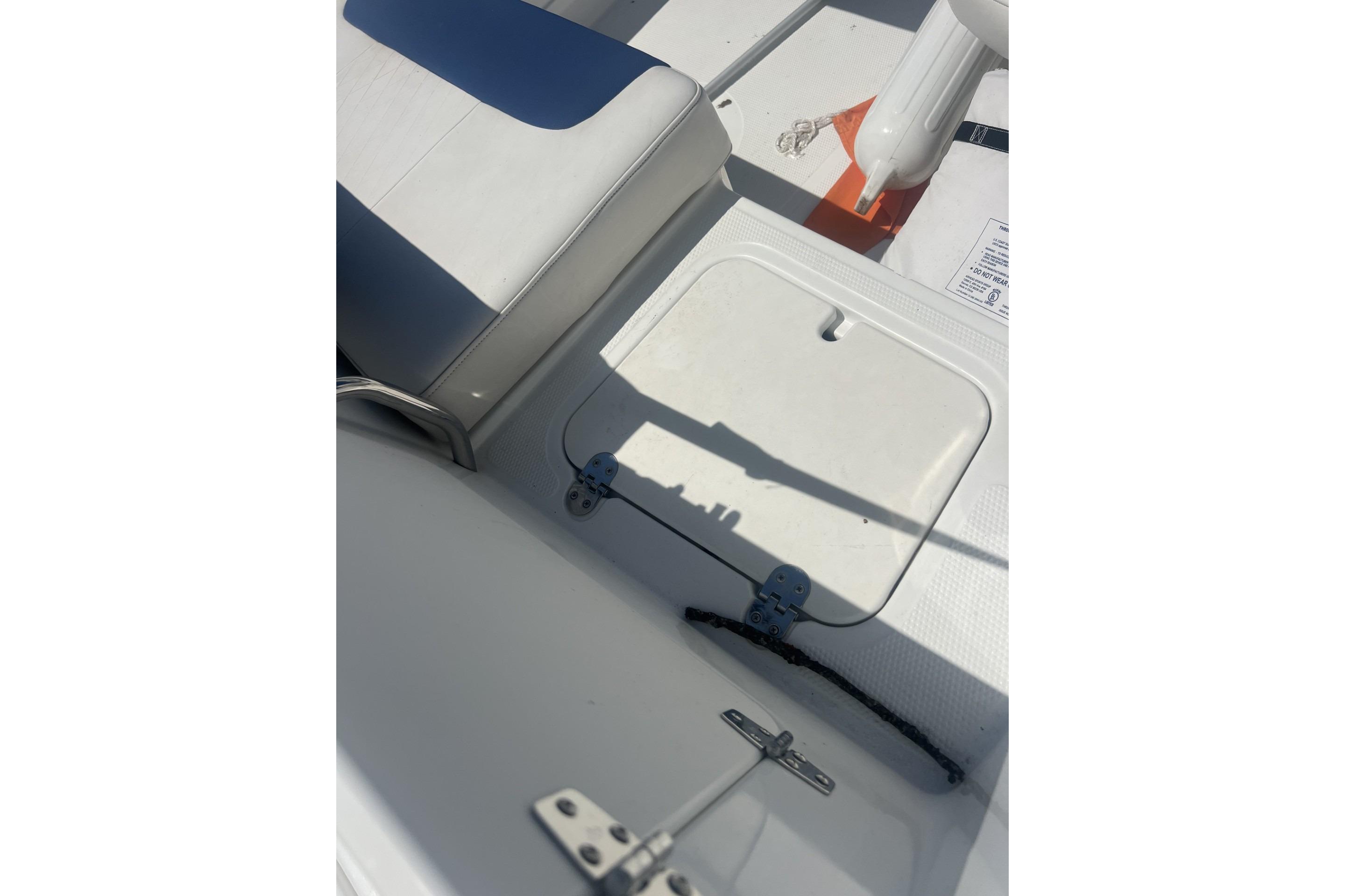 2017 Tahoe 2150 boat interior with white seating and storage compartment.