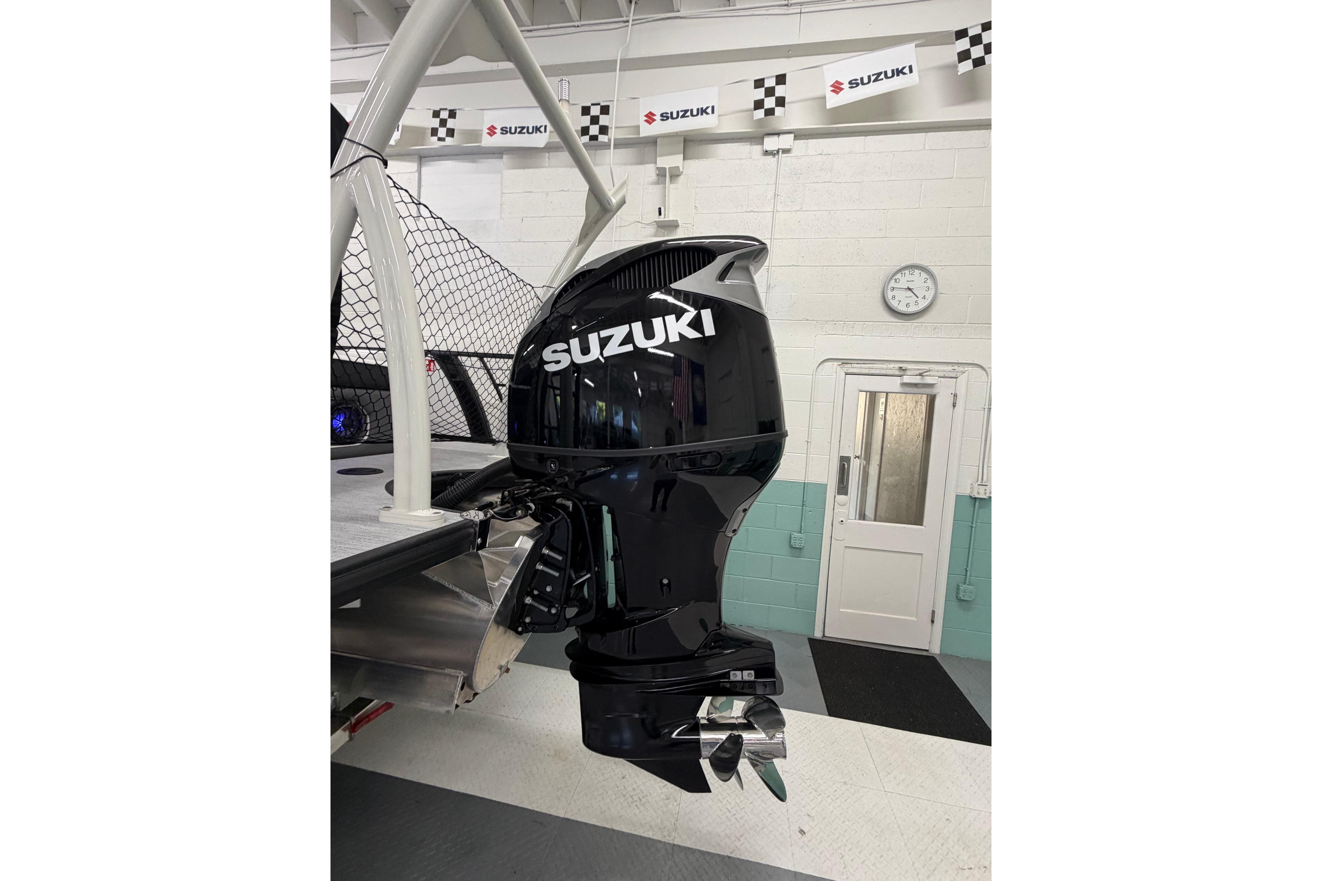 Outboard motor on a 2026 South Bay 525SB2 boat in a Suzuki showroom.