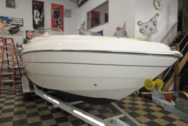 2004 Stingray 240 LR boat on trailer in showroom with checkered floor.