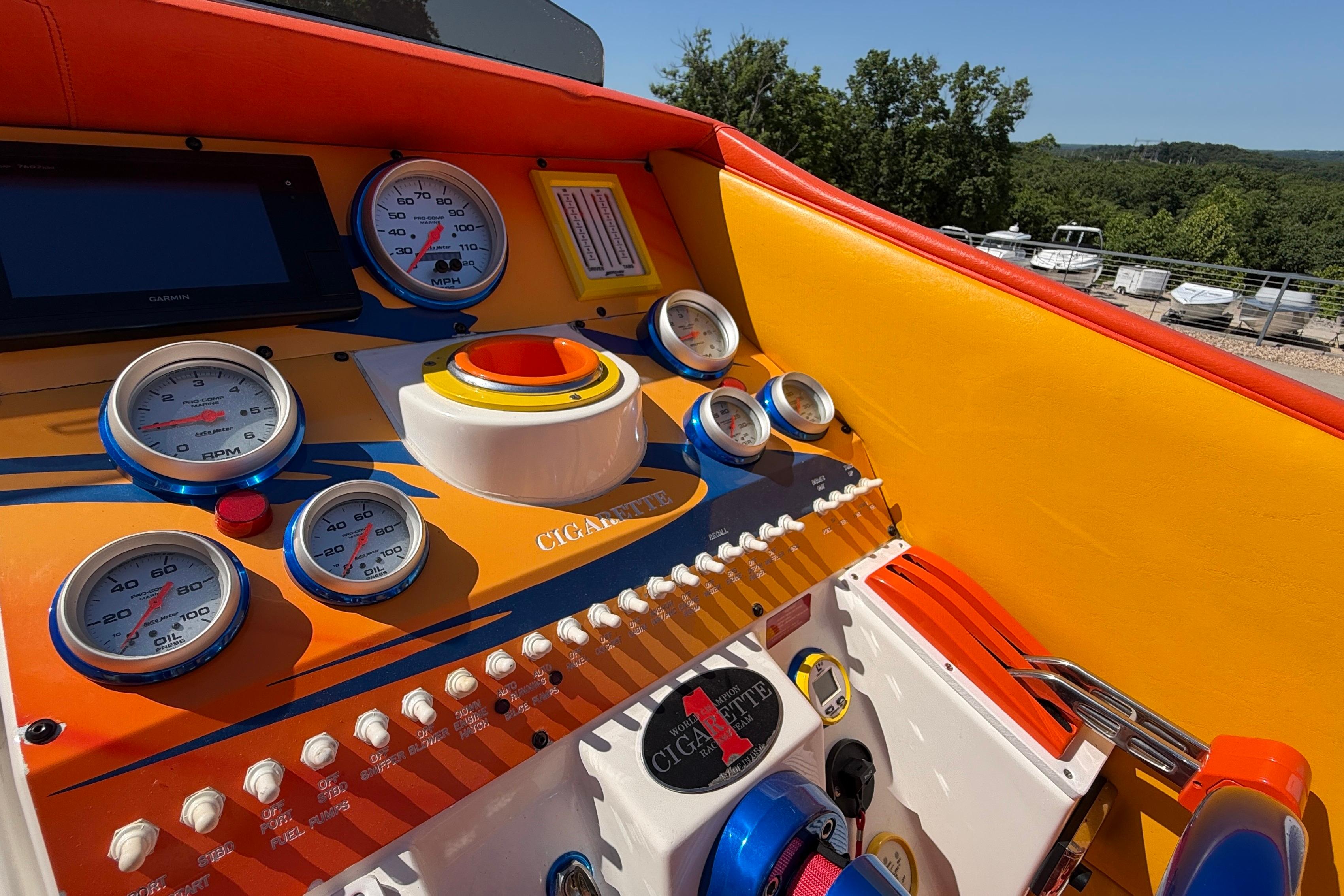 2002 Cigarette 35' Cafe Racer dashboard with vibrant orange and yellow design, featuring multiple gauges.