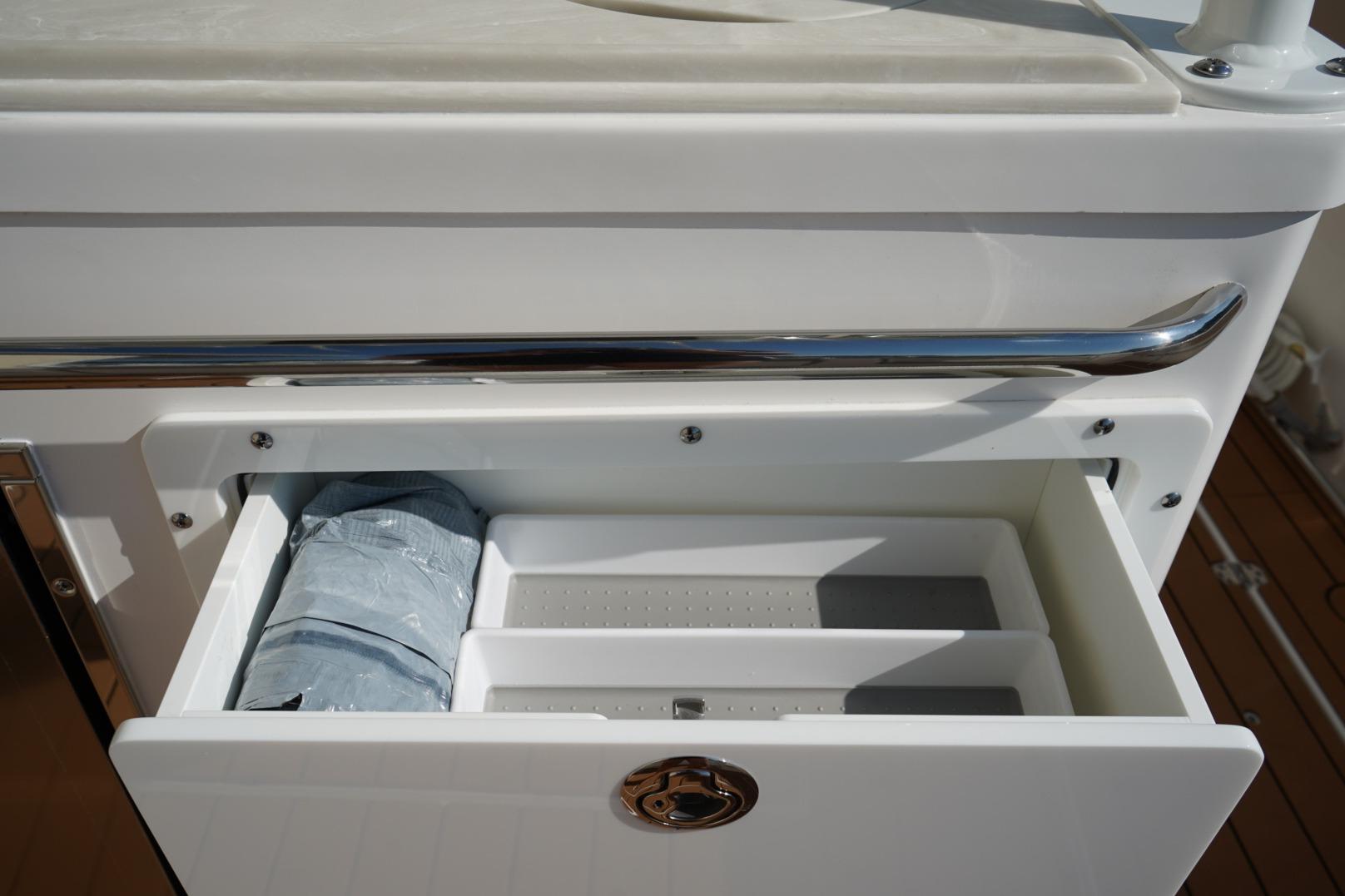 2024 Edgewater 285CC boat storage compartment with open drawer and packaged item.