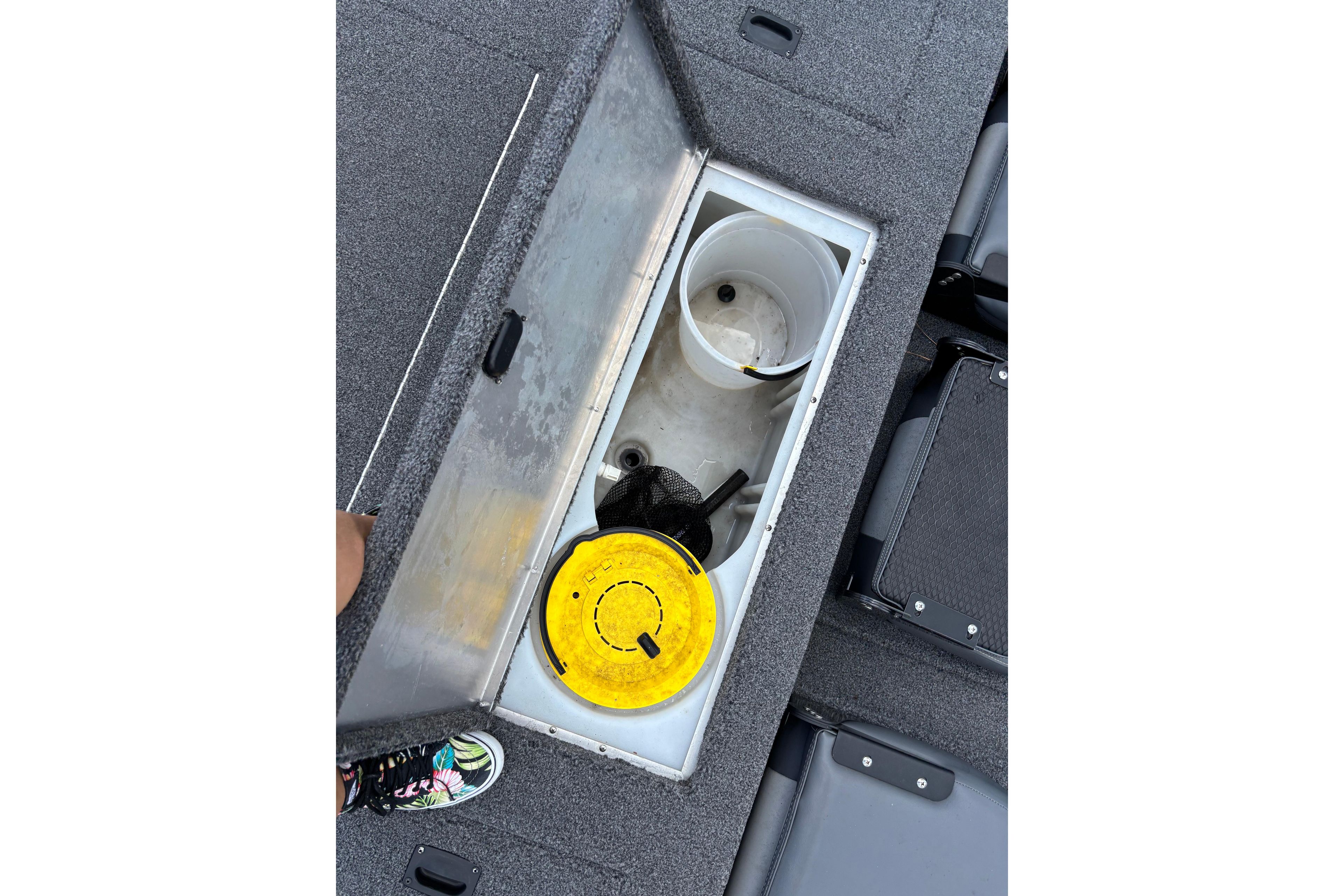 Open storage compartment in 2021 Lowe Stinger 175C boat with fishing gear.