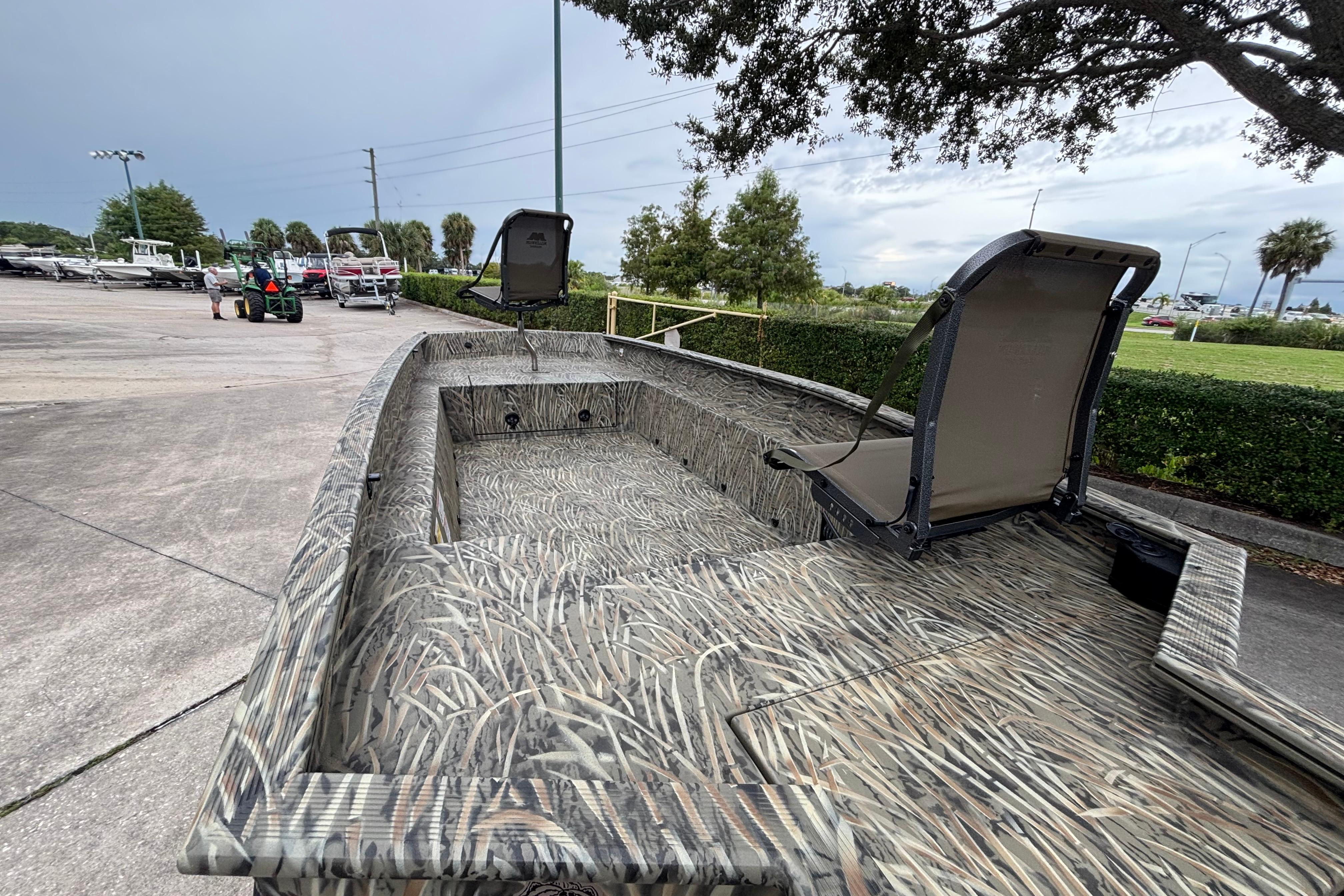2026 Tracker Grizzly 1650 T Prairie Wings Edition boat with camouflage design, parked outdoors.