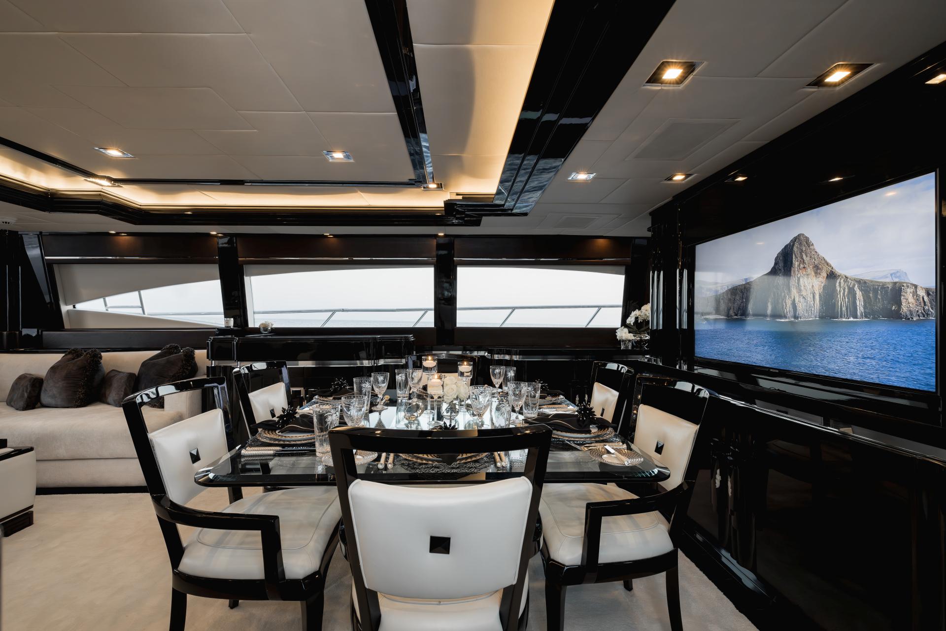 Luxurious interior of 2008 Mangusta 108 yacht with elegant dining area and scenic view.