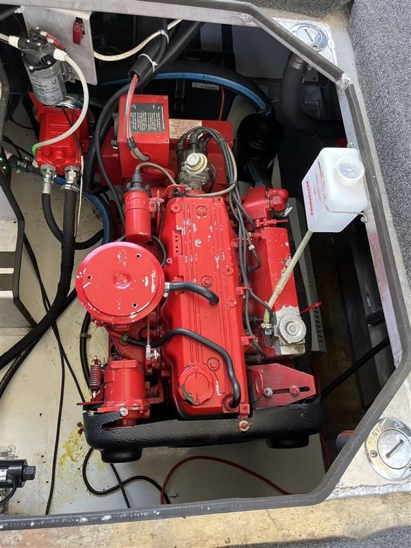 Red engine inside a 1998 Sumerset houseboat, showcasing mechanical components and wiring.