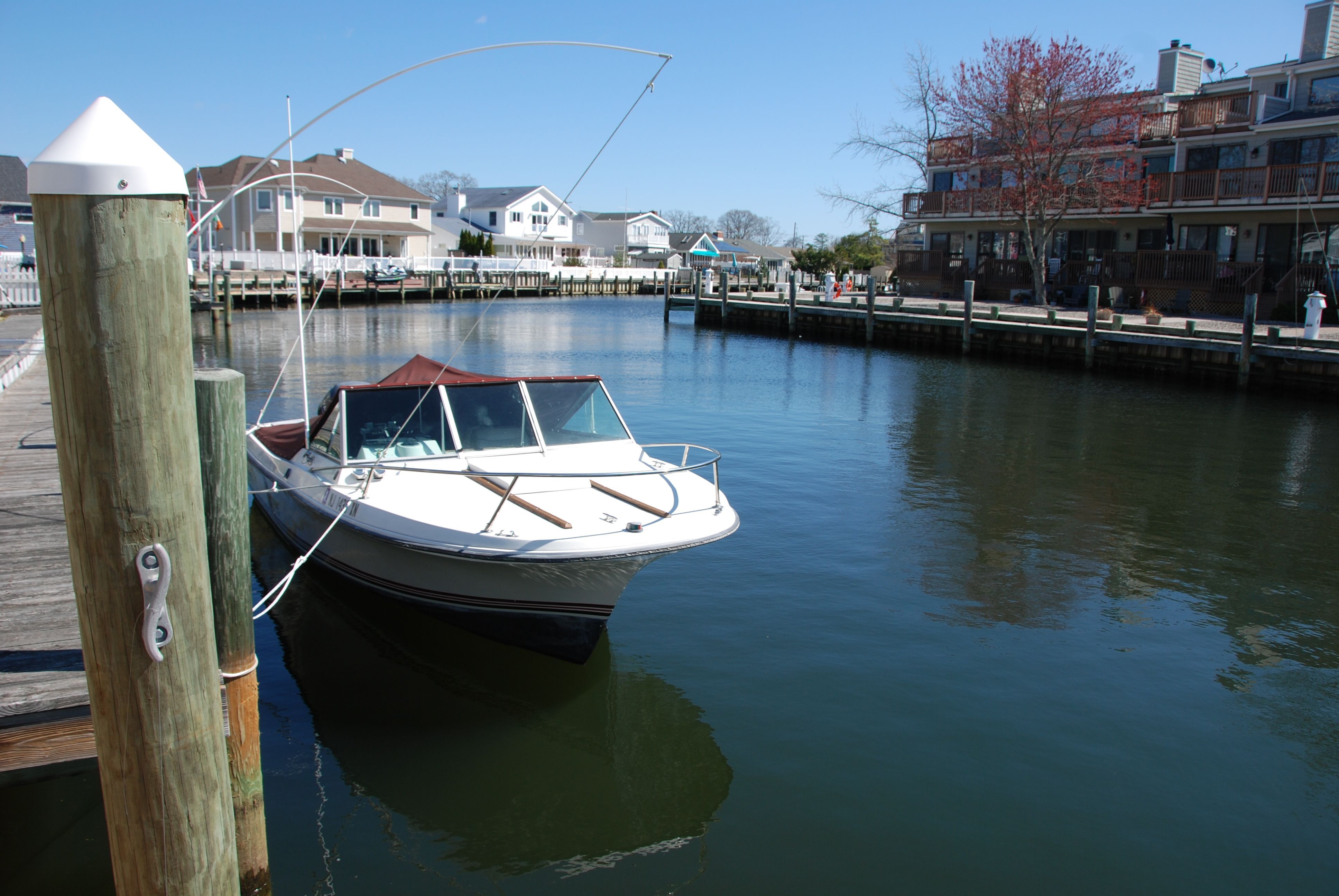 A 1987 Wellcraft V-20 Steplift docked in a calm residential area.