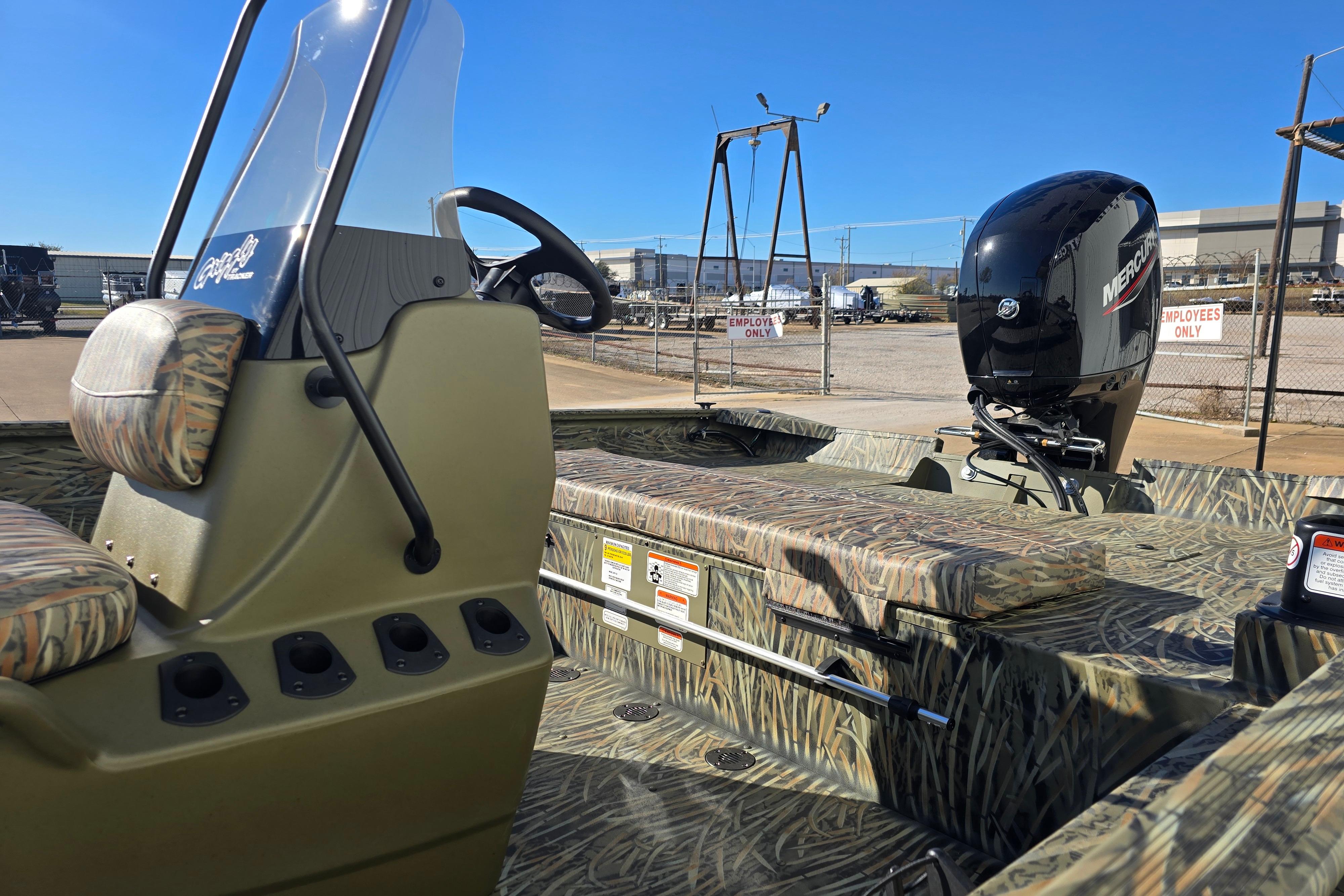 2026 Tracker Grizzly 2072 CC boat with camouflage seating and Mercury outboard motor.