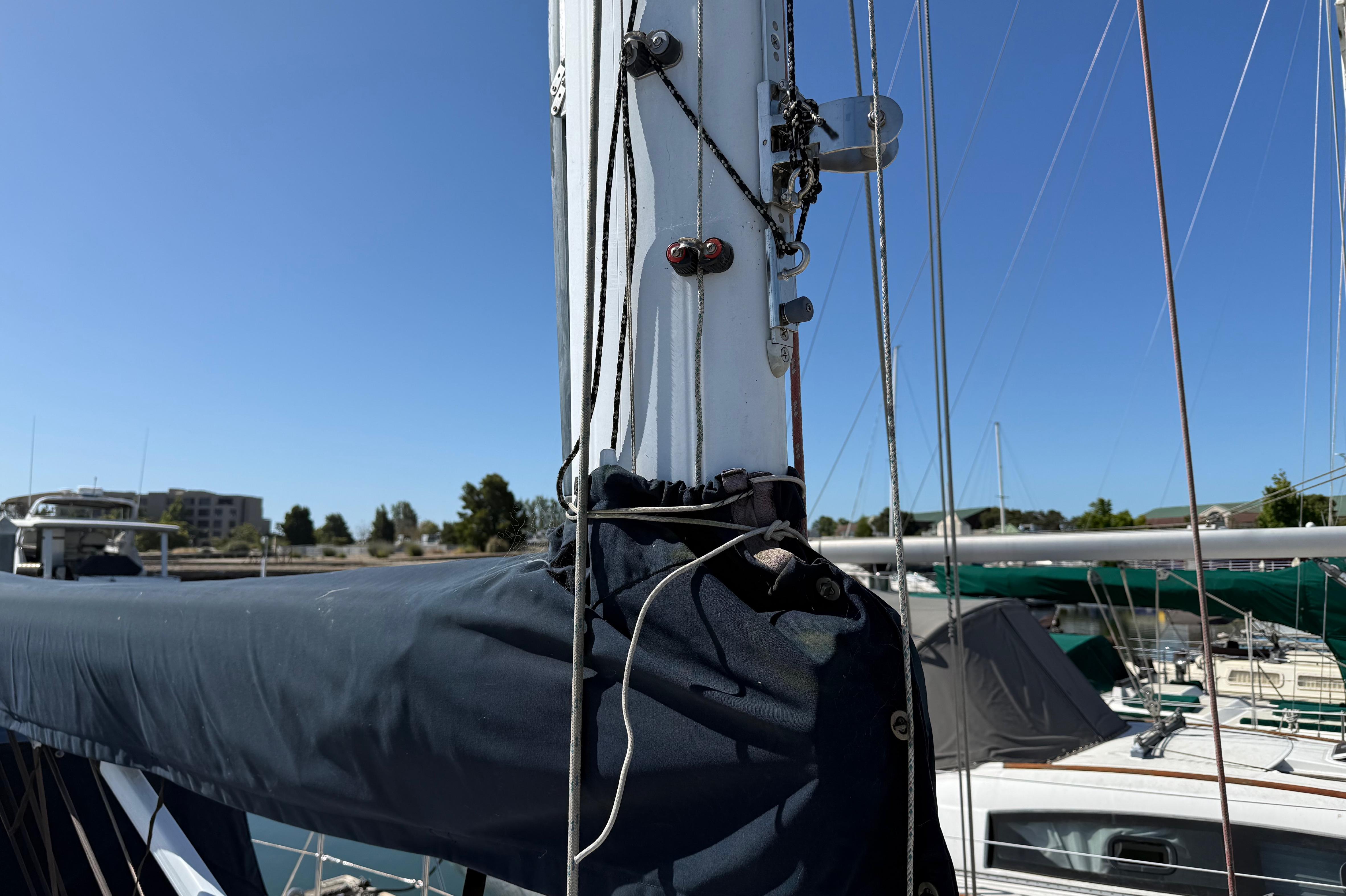 Mast and rigging of a 2004 Sabre 386 sailboat in a marina under clear blue sky.