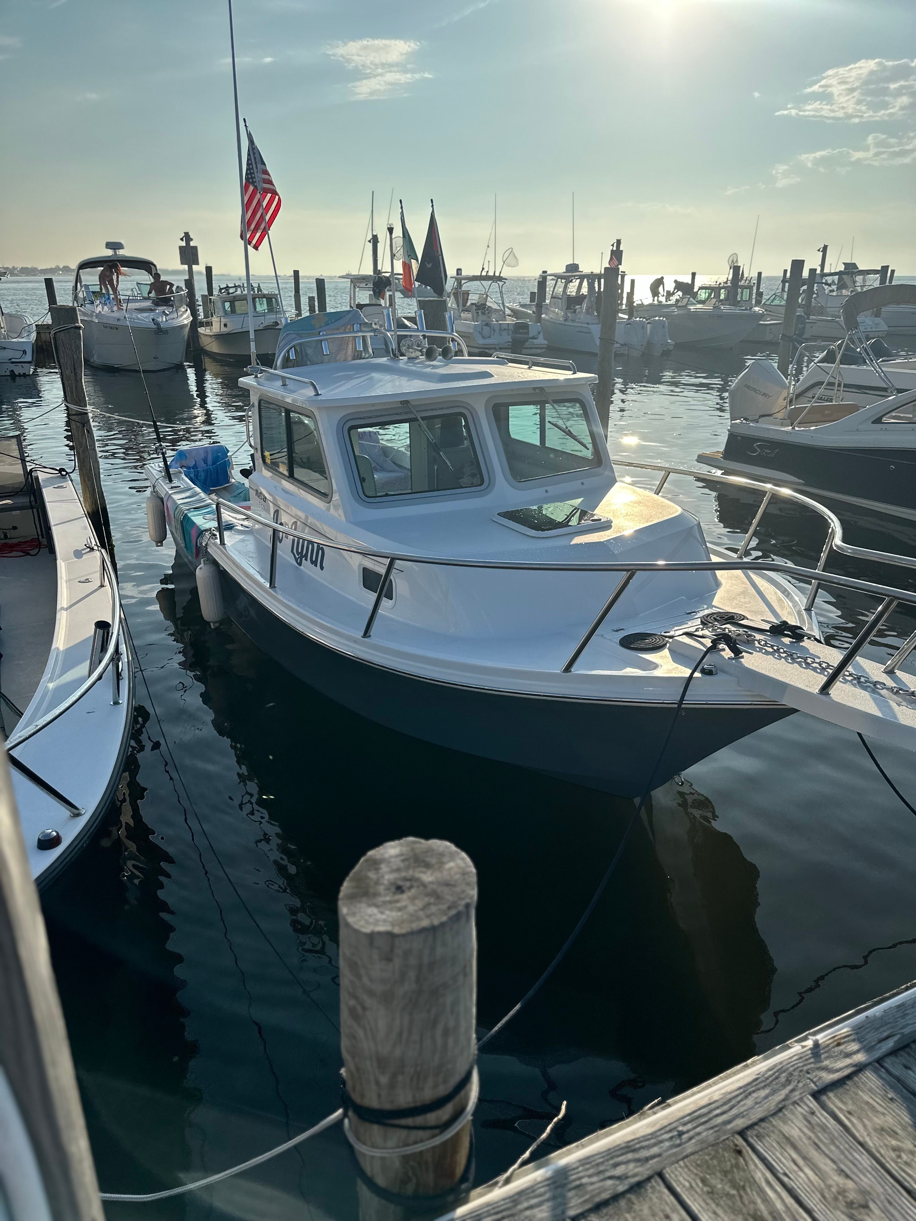 Parker 2021 sport cabin, year 2022, docked in a sunny marina with other boats.