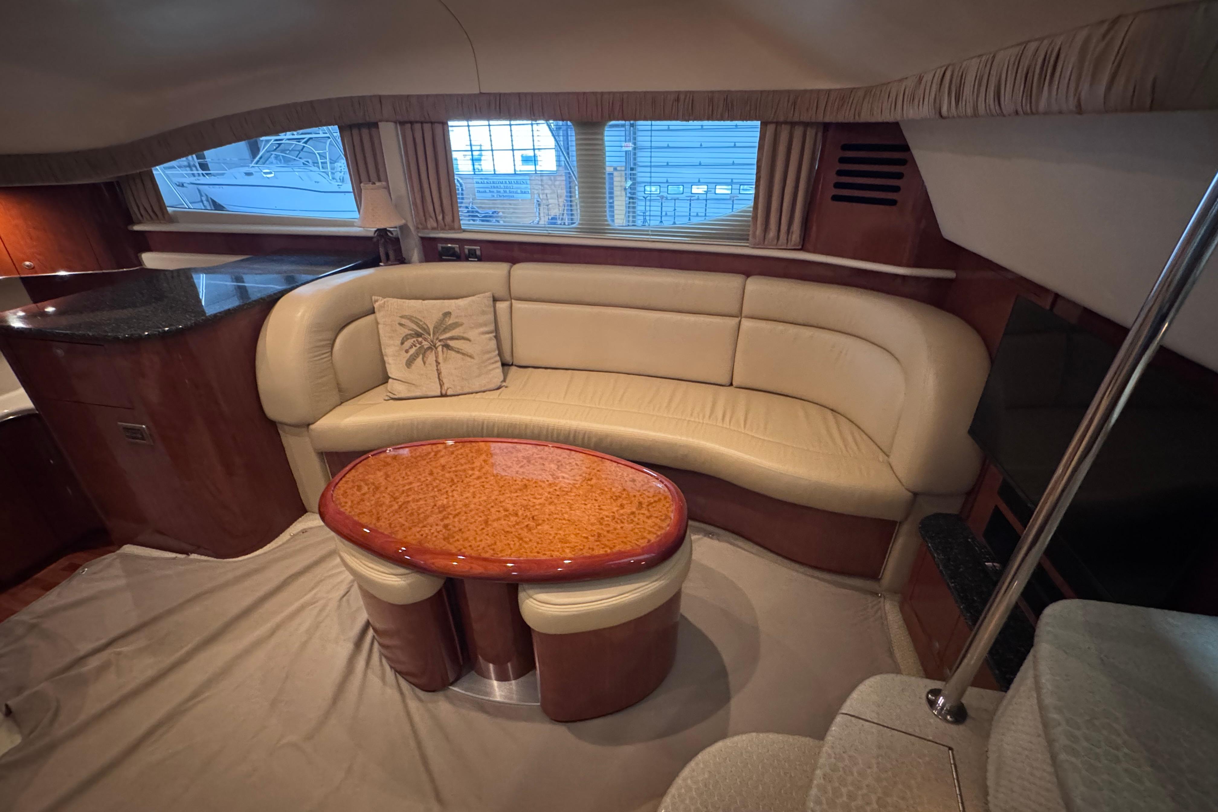 Luxurious 2004 Sea Ray 390 Motor Yacht interior with elegant seating and polished wood table.