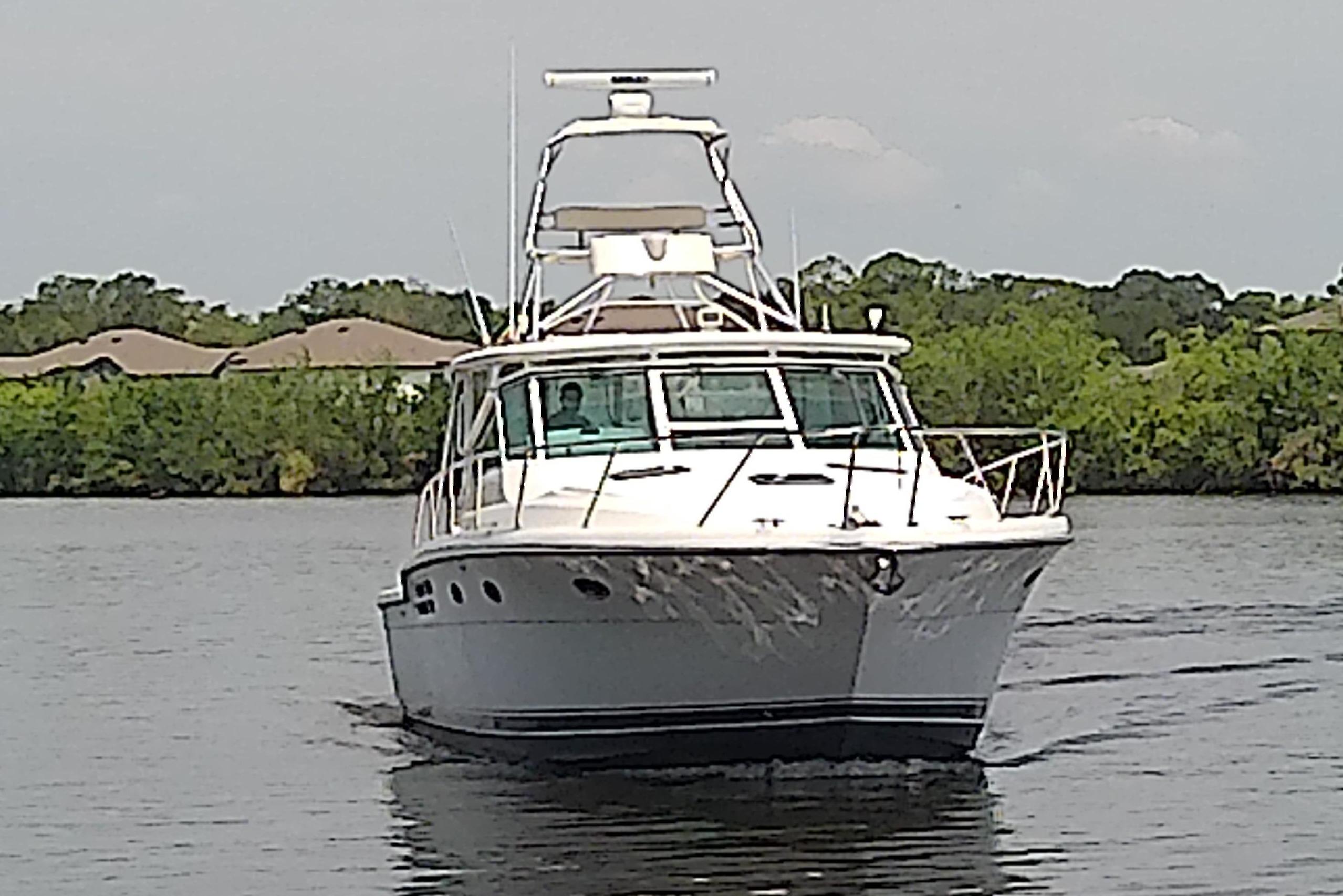 2000 Tiara Yachts 4100 Open cruising on a calm river with lush greenery.