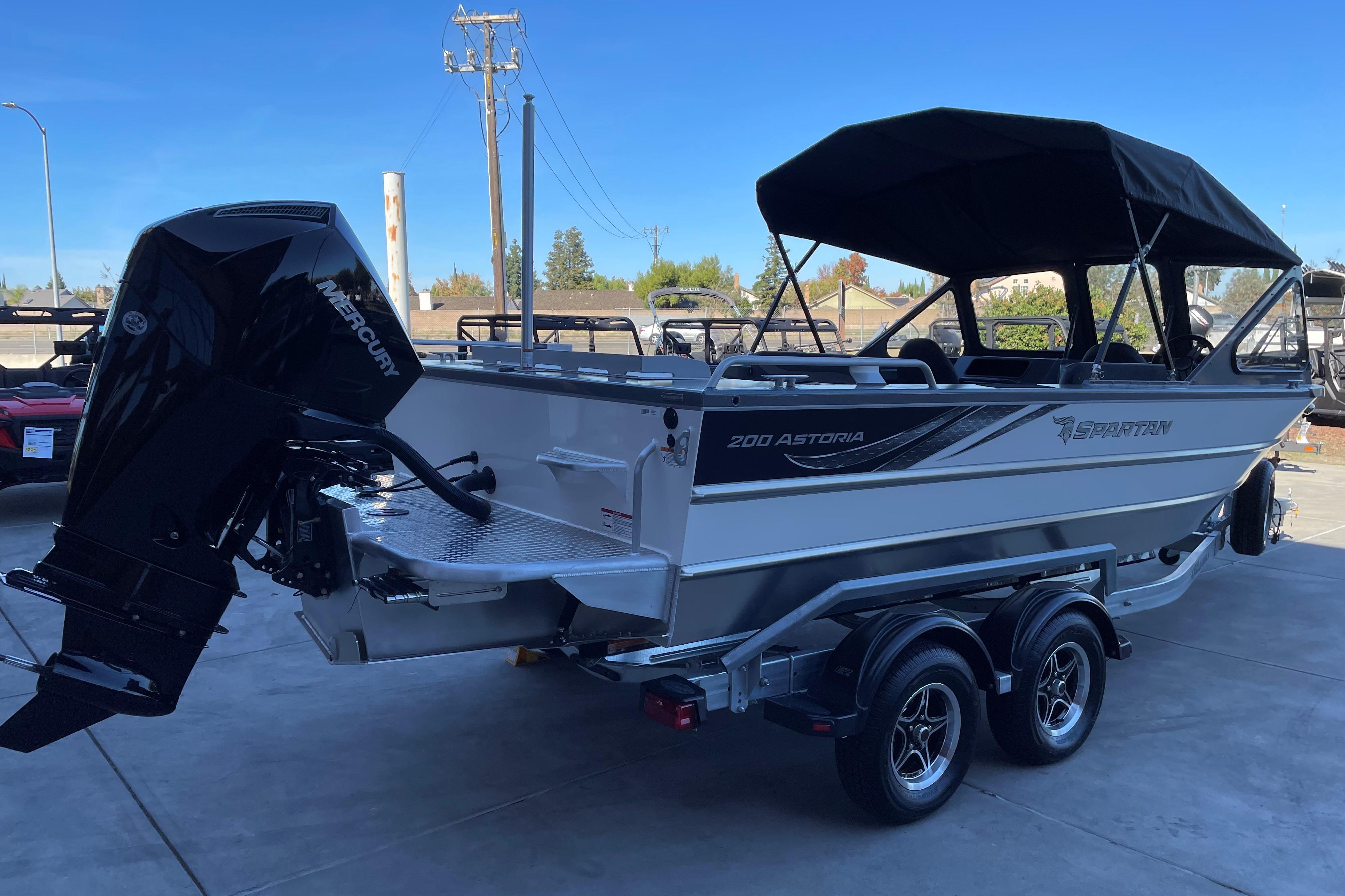 2025 Spartan 200 Astoria boat with Mercury outboard engine on a trailer.