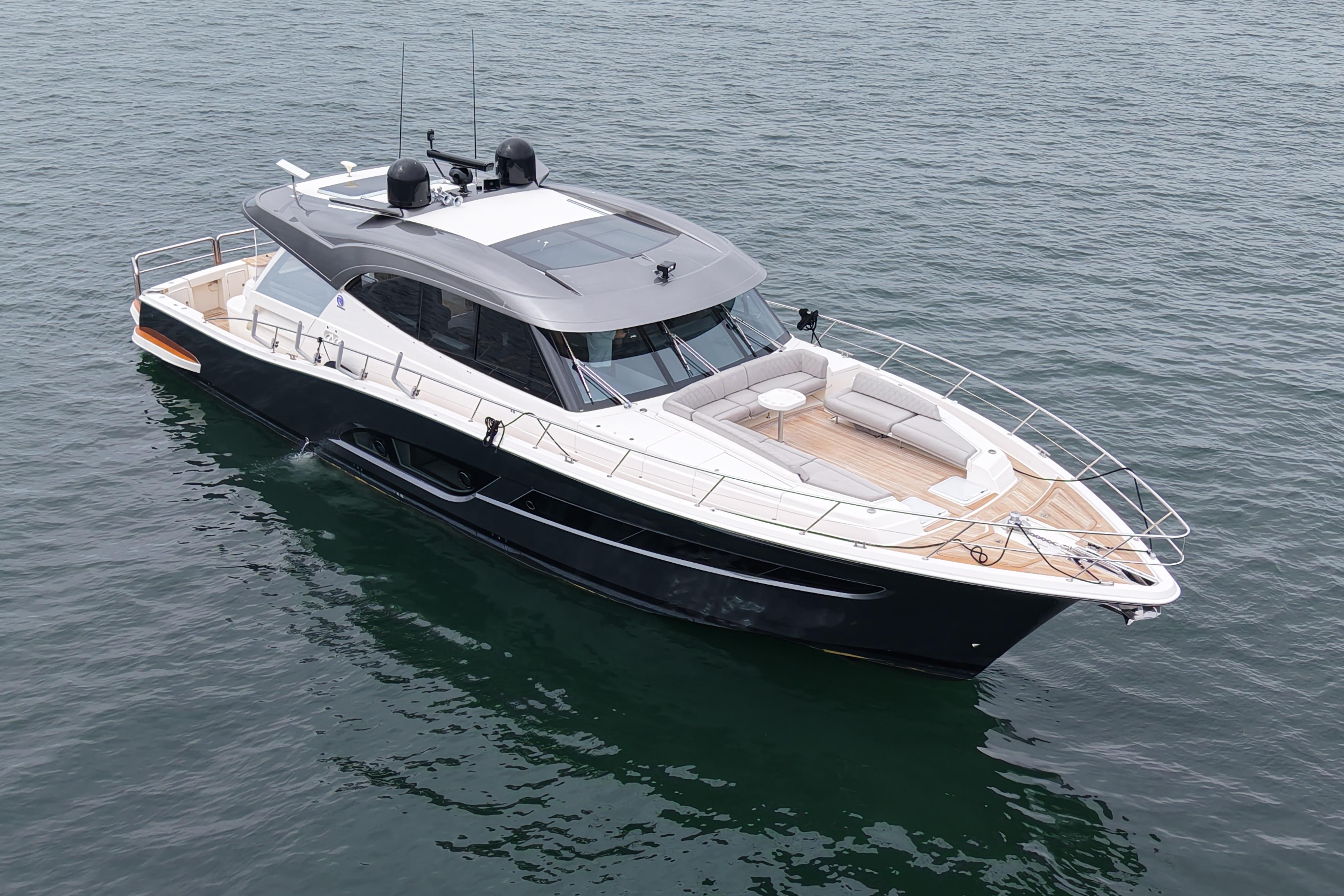 2023 Riviera 645 SUV luxury yacht on calm water, showcasing sleek design and spacious deck.