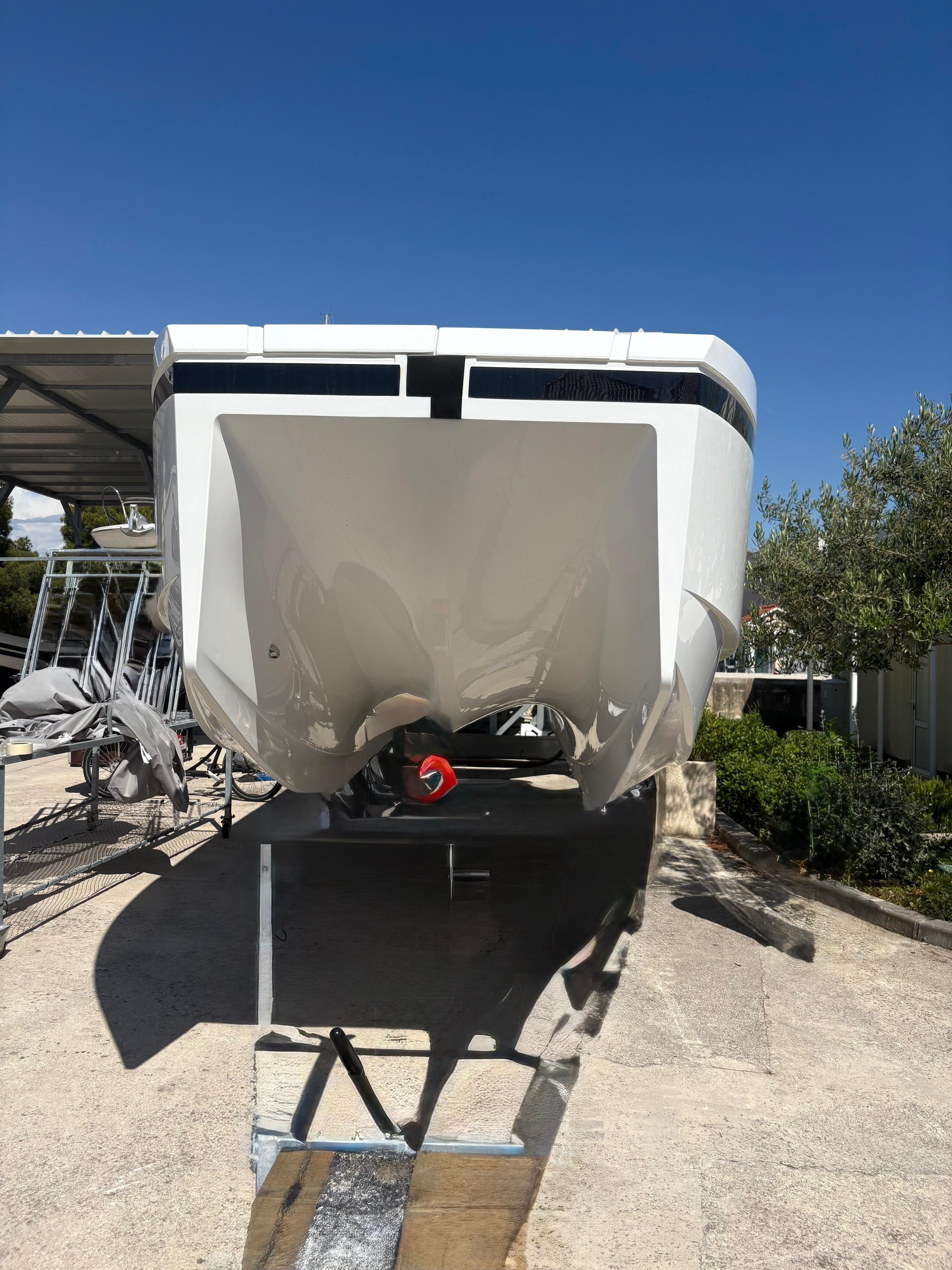 2025 De Antonio Yachts e23 Open, sleek design, docked under clear blue sky.