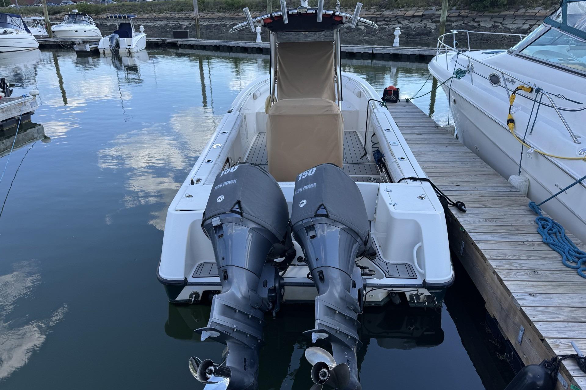 2007 Edgewater 245CC boat docked with twin outboard engines in a marina setting.