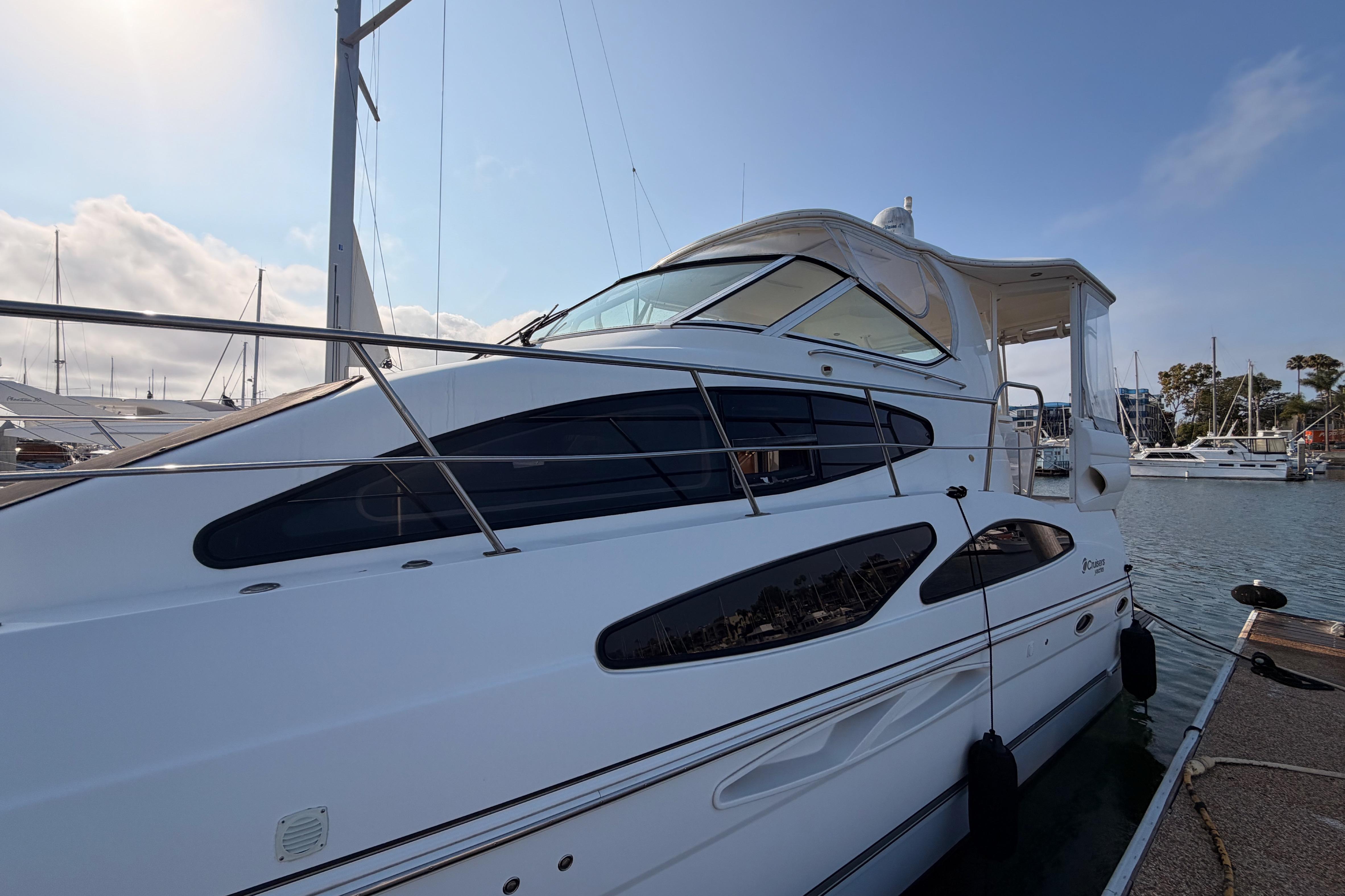 2005 Cruisers Yachts 405 Express Motoryacht docked at marina under clear sky.