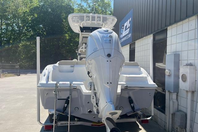 2026 Key West 239 FS boat with outboard motor, parked outside a building.