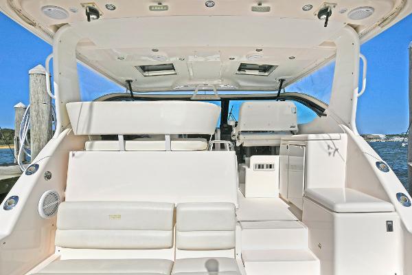2008 Tiara Yachts 4200 Open interior with white seating and helm, docked by the water.