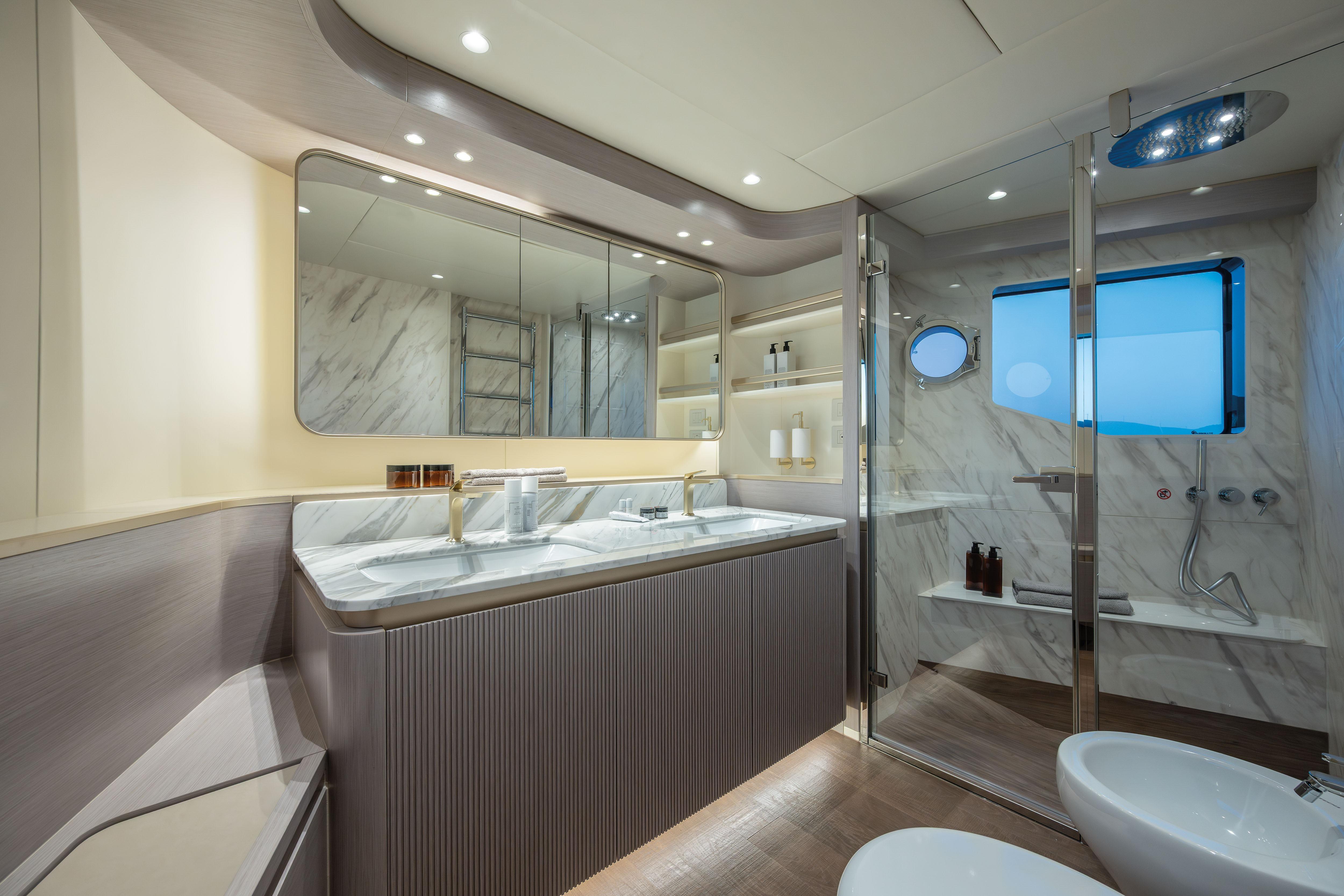 Luxurious bathroom with double sinks, large mirror, shower, and elegant lighting.