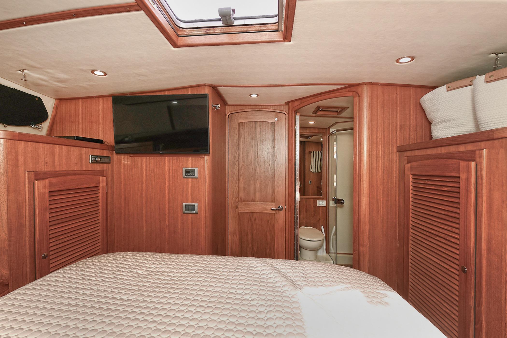 Luxurious 2005 San Juan Downeast Express cabin interior with wood paneling and modern amenities.