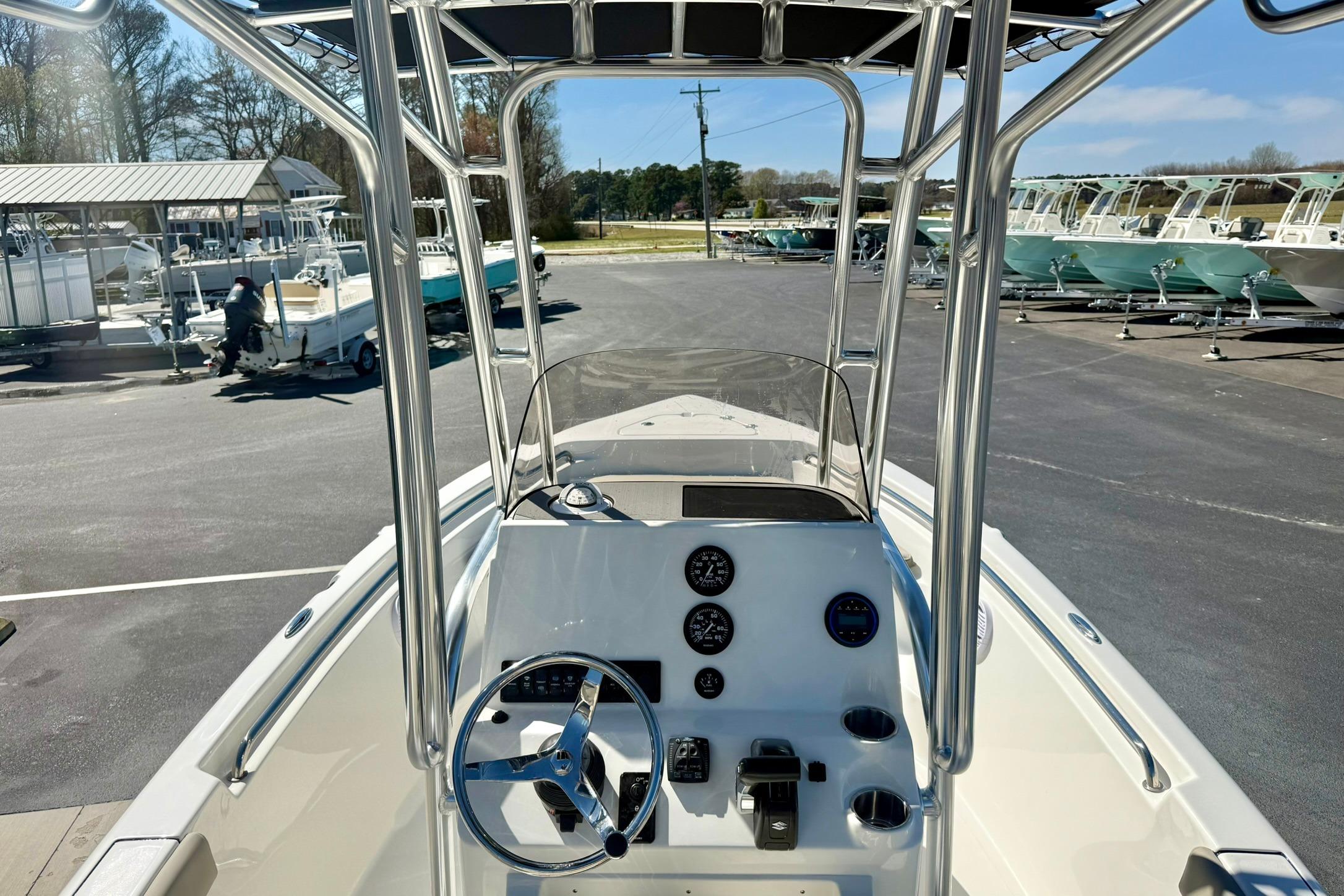 2026 Key West 189 FS boat interior with steering console and gauges in a marina setting.