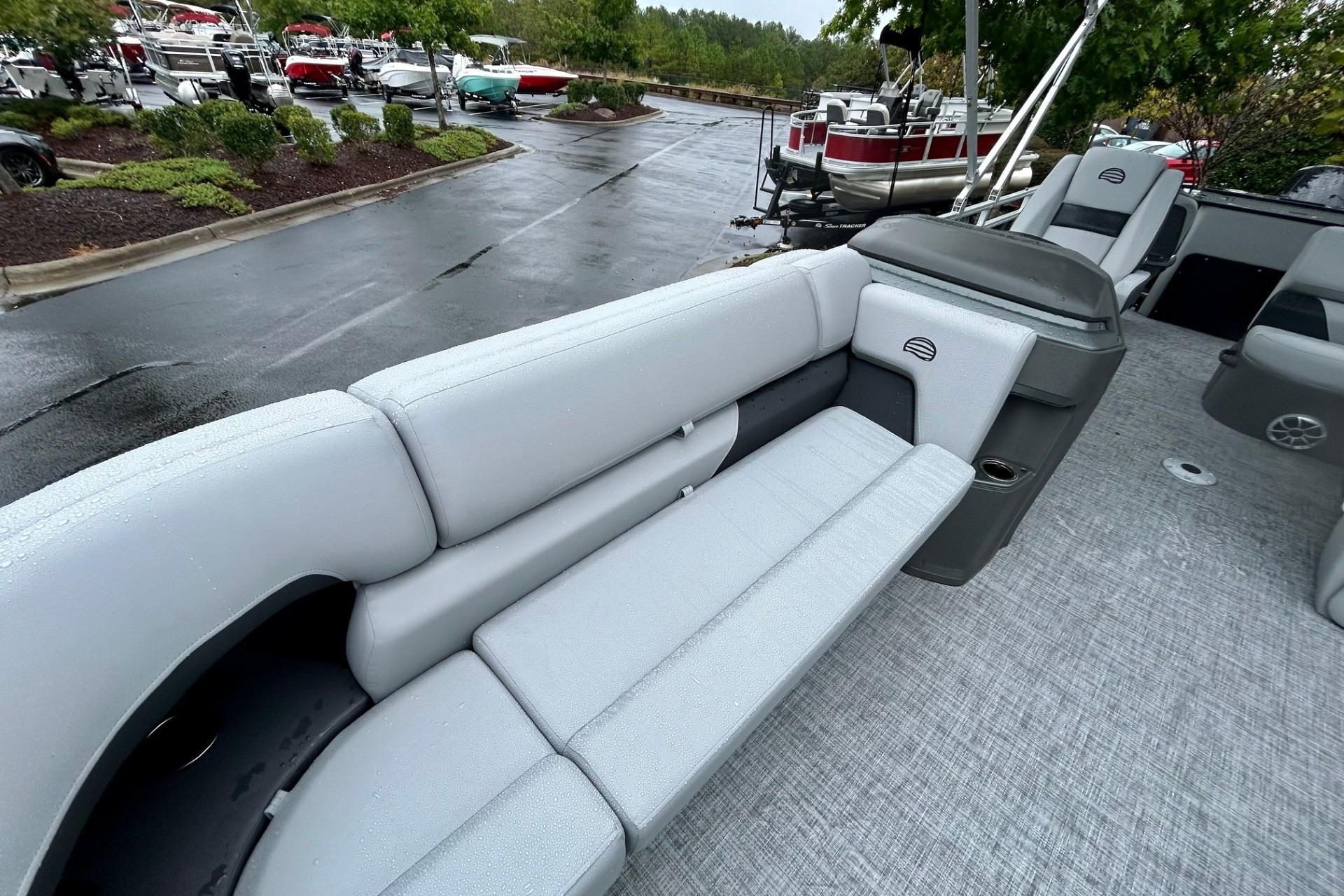 2026 Sun Tracker SportFish 22 DLX pontoon boat with gray seating and wet deck.