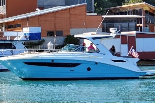 2016 Sea Ray Sundancer 350 yacht docked near waterfront buildings.