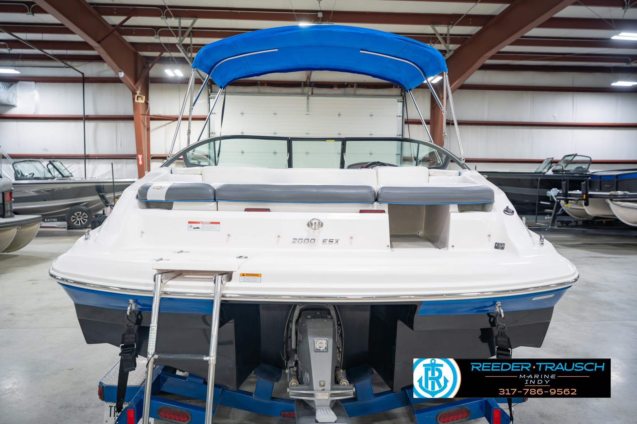 2015 Regal 2000 ESX Bowrider with blue canopy in indoor showroom.