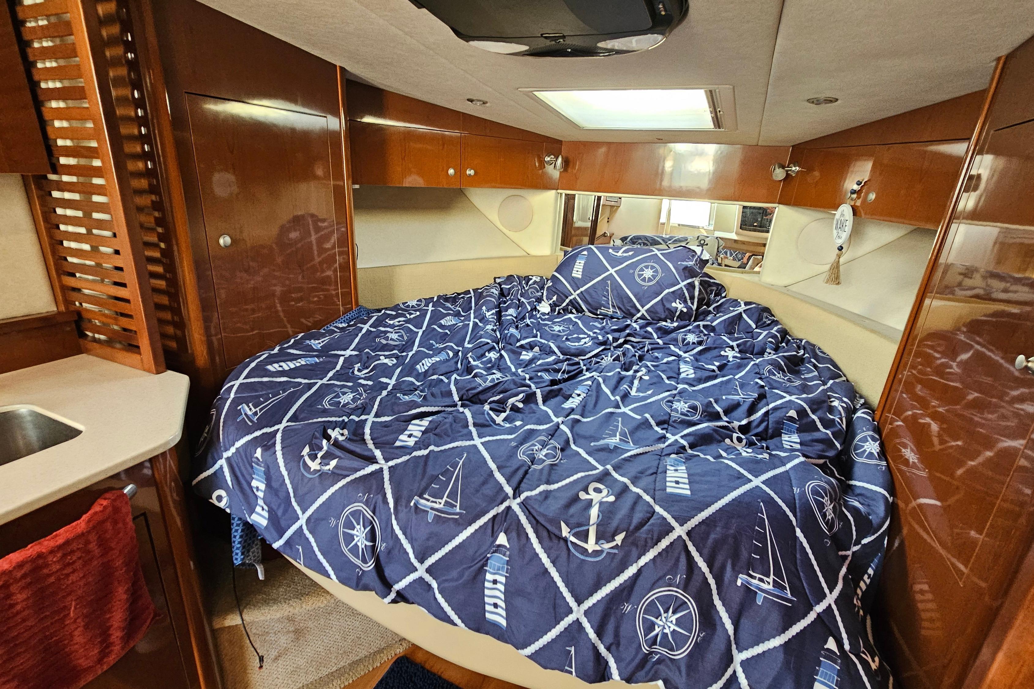 Luxurious cabin interior of 2008 Sea Ray Sundancer 350 with nautical-themed bedding.