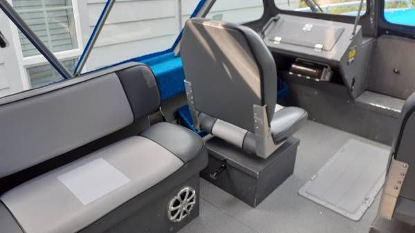 Interior of a boat with gray seating and blue accents.