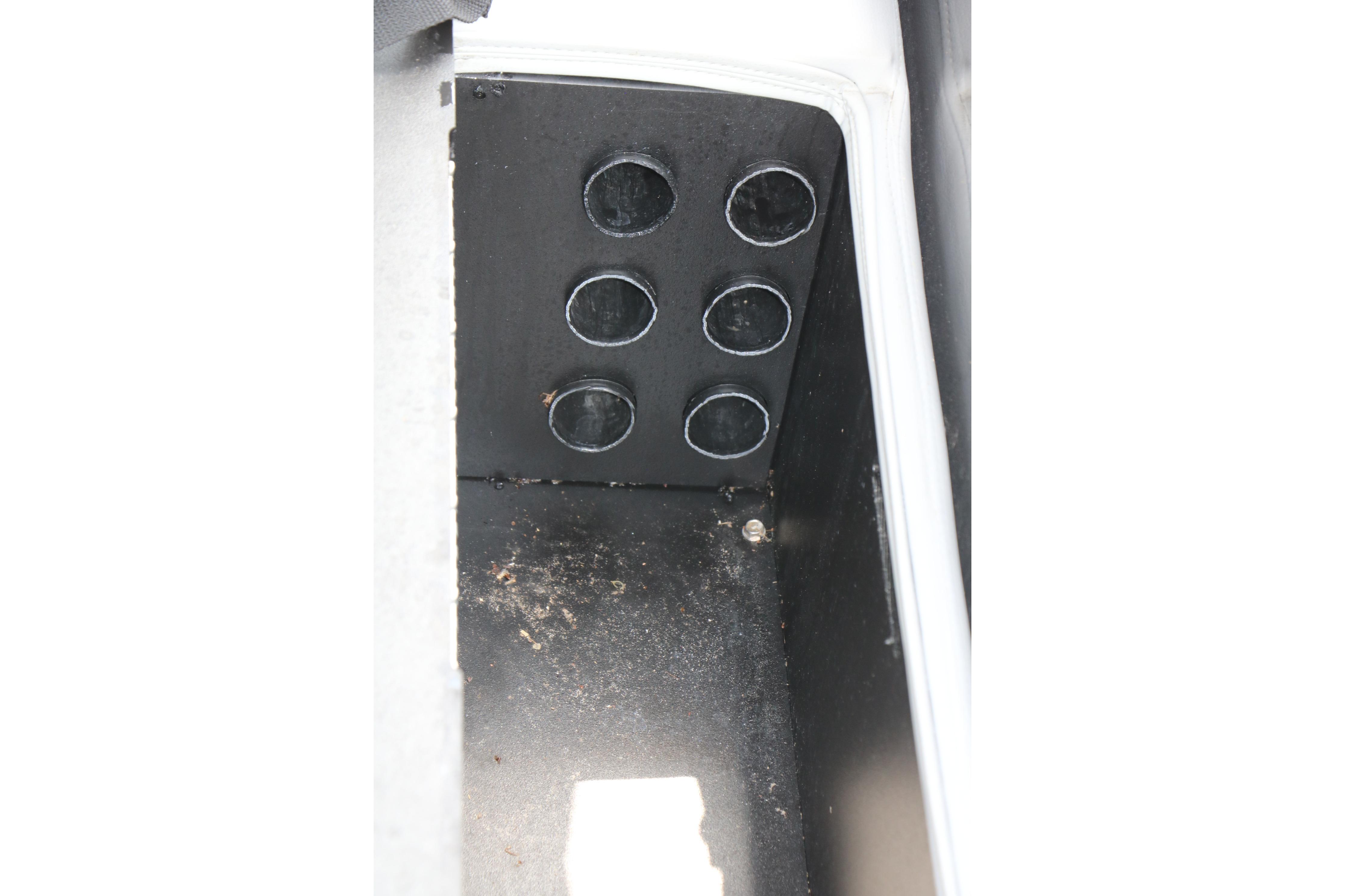 Interior compartment of 2021 Ranger 223FC boat with circular storage slots.