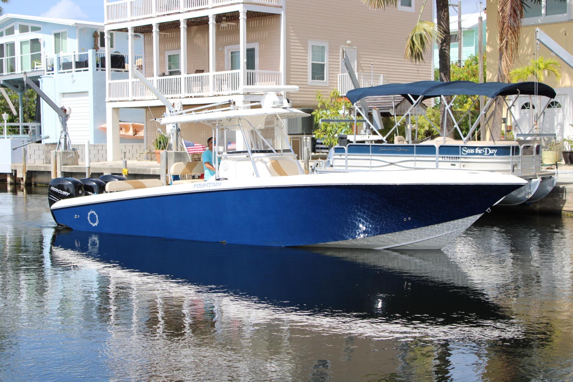 2007 Fountain 34 Center Console boat docked near waterfront homes.