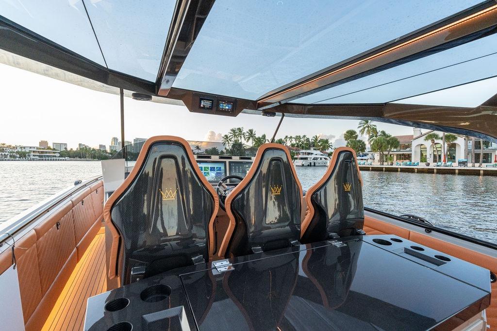 Luxurious 2023 DeKoning 43 yacht interior with sleek seating and waterfront view.