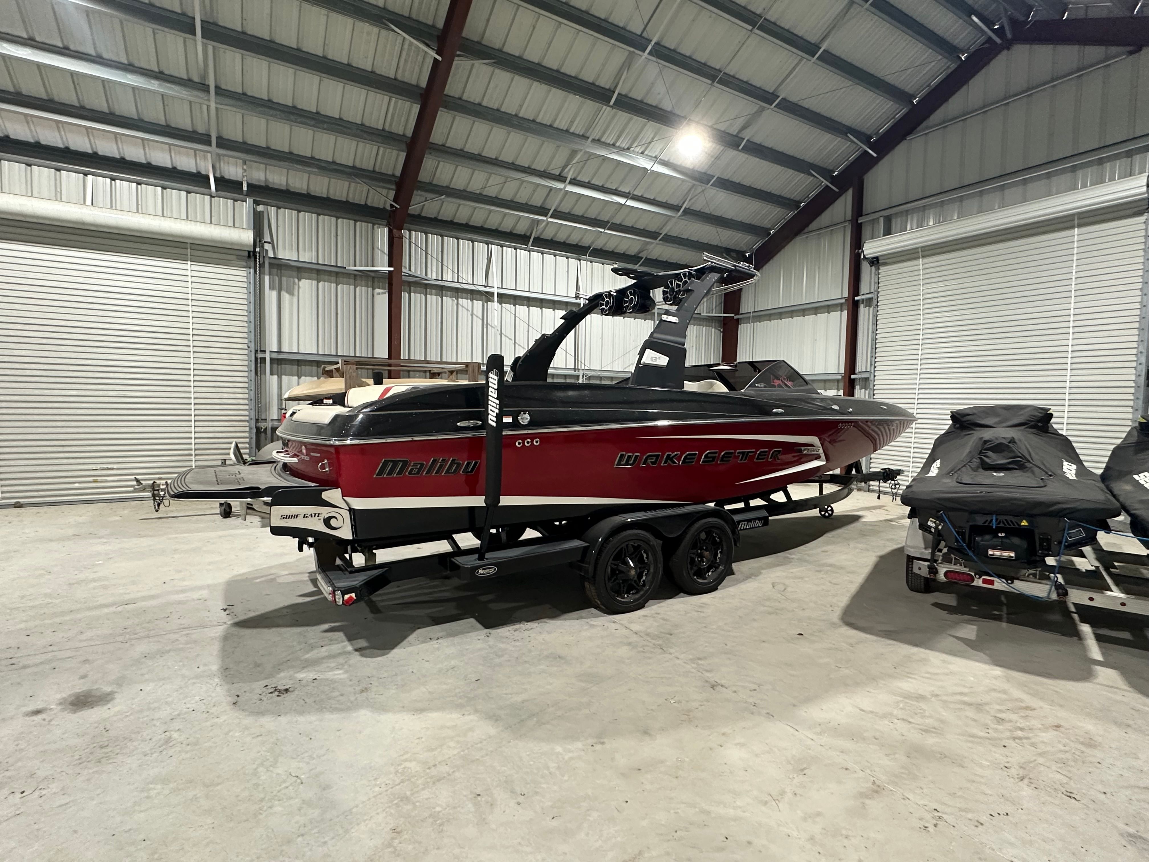 A Malibu Wakesetter 24 MXZ boat is parked inside a storage facility.