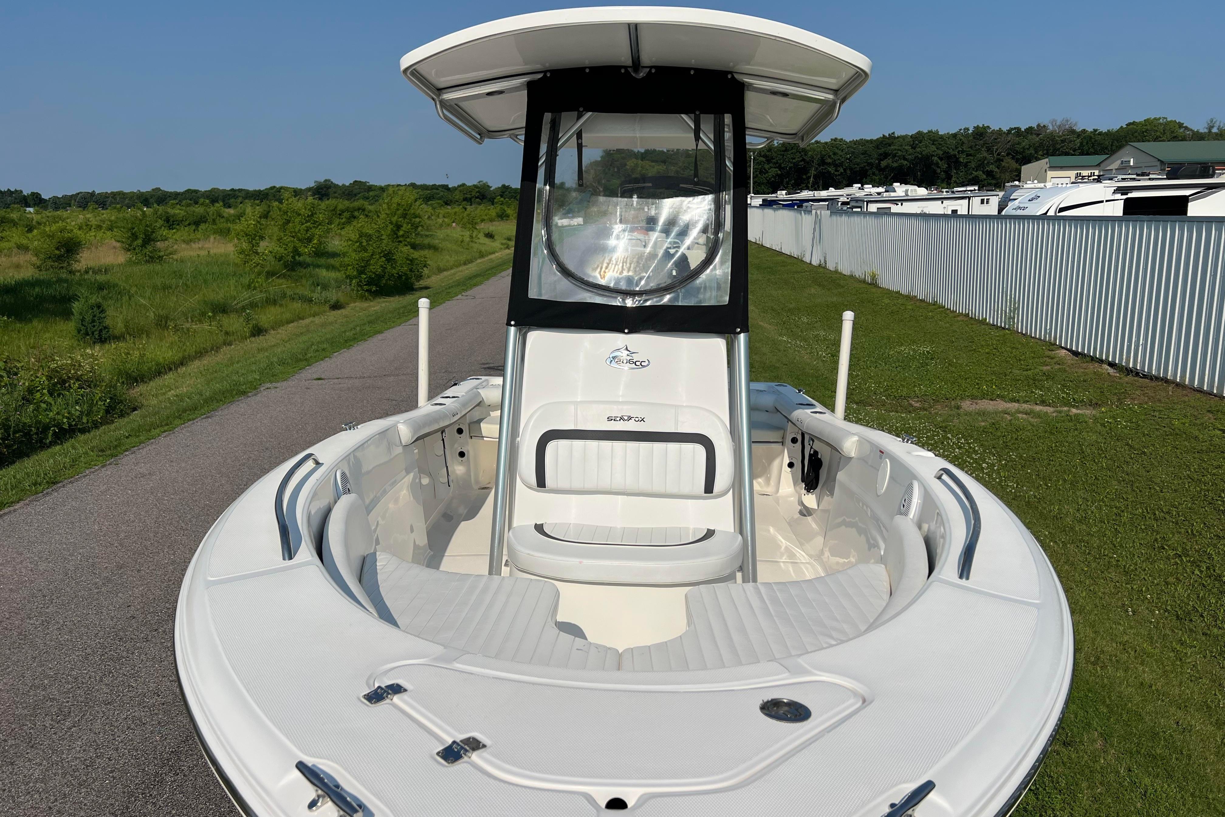 2012 Sea Fox 206 Center Console boat on a sunny day, parked near greenery.