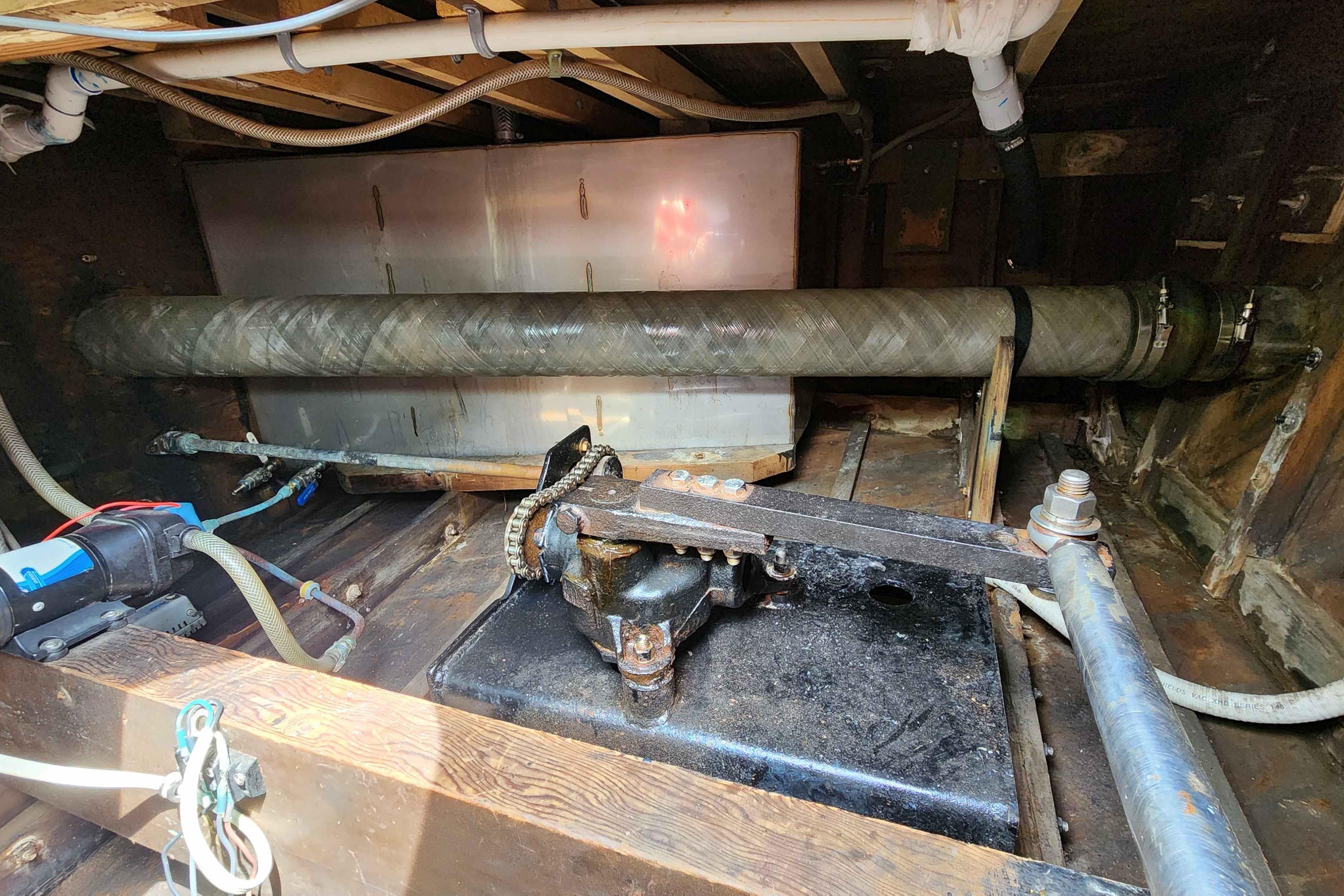 Interior view of a 1964 Grandy Tour Boat engine compartment with visible pipes and machinery.