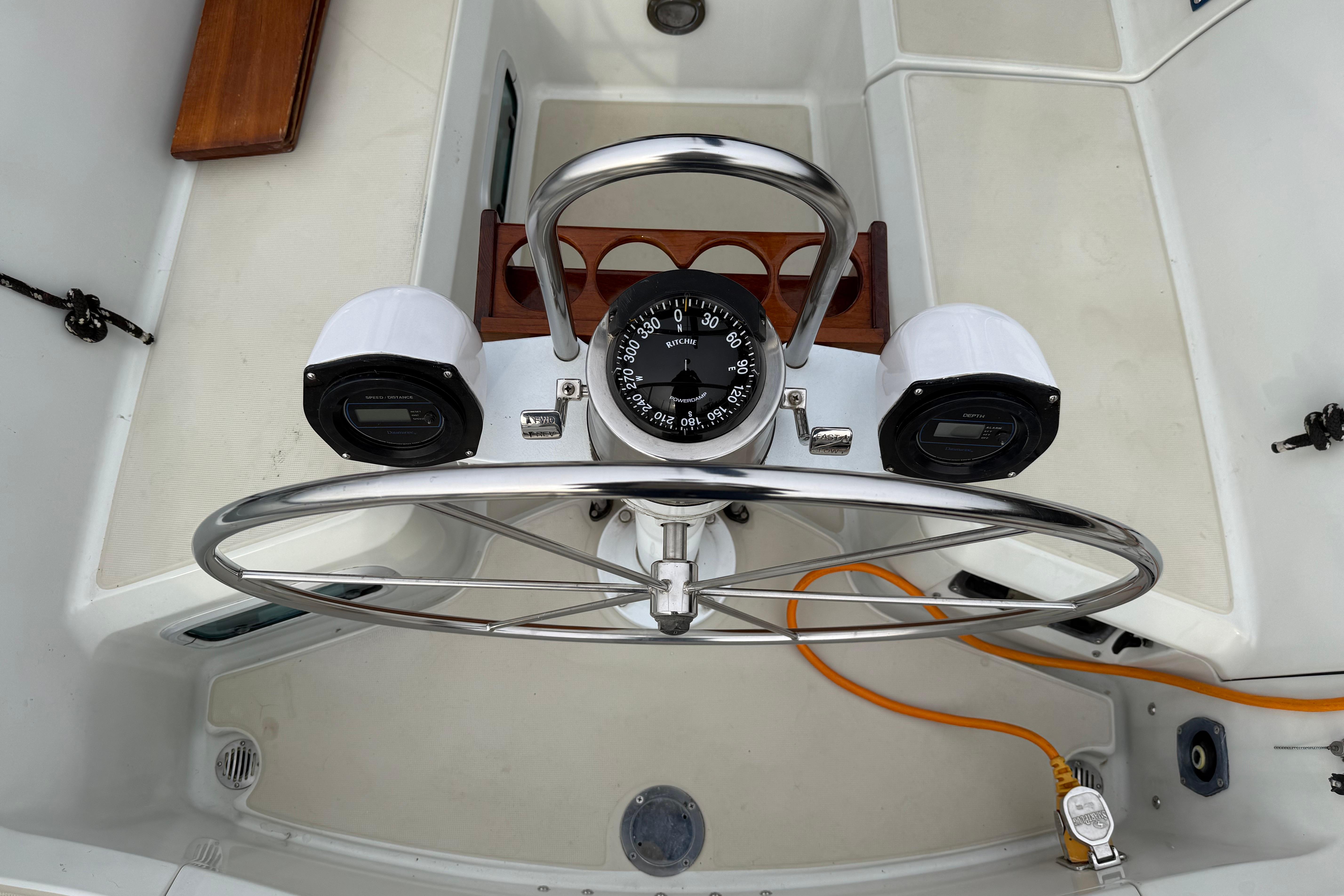 Steering wheel and compass on a 1988 Ericson 32-200 sailboat cockpit.