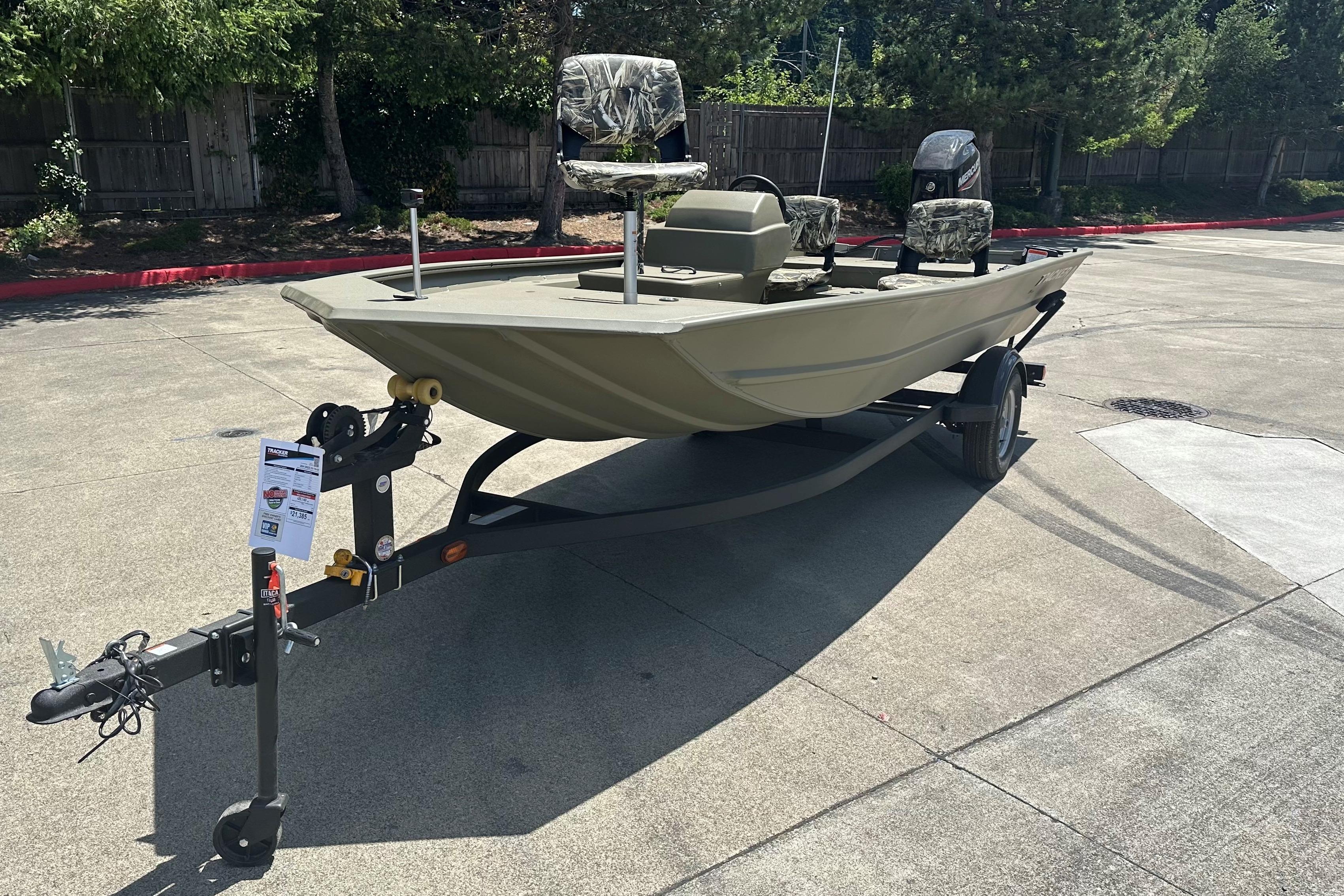 2026 Tracker Grizzly 1754 SC boat on trailer, parked outdoors, featuring camouflage seats.