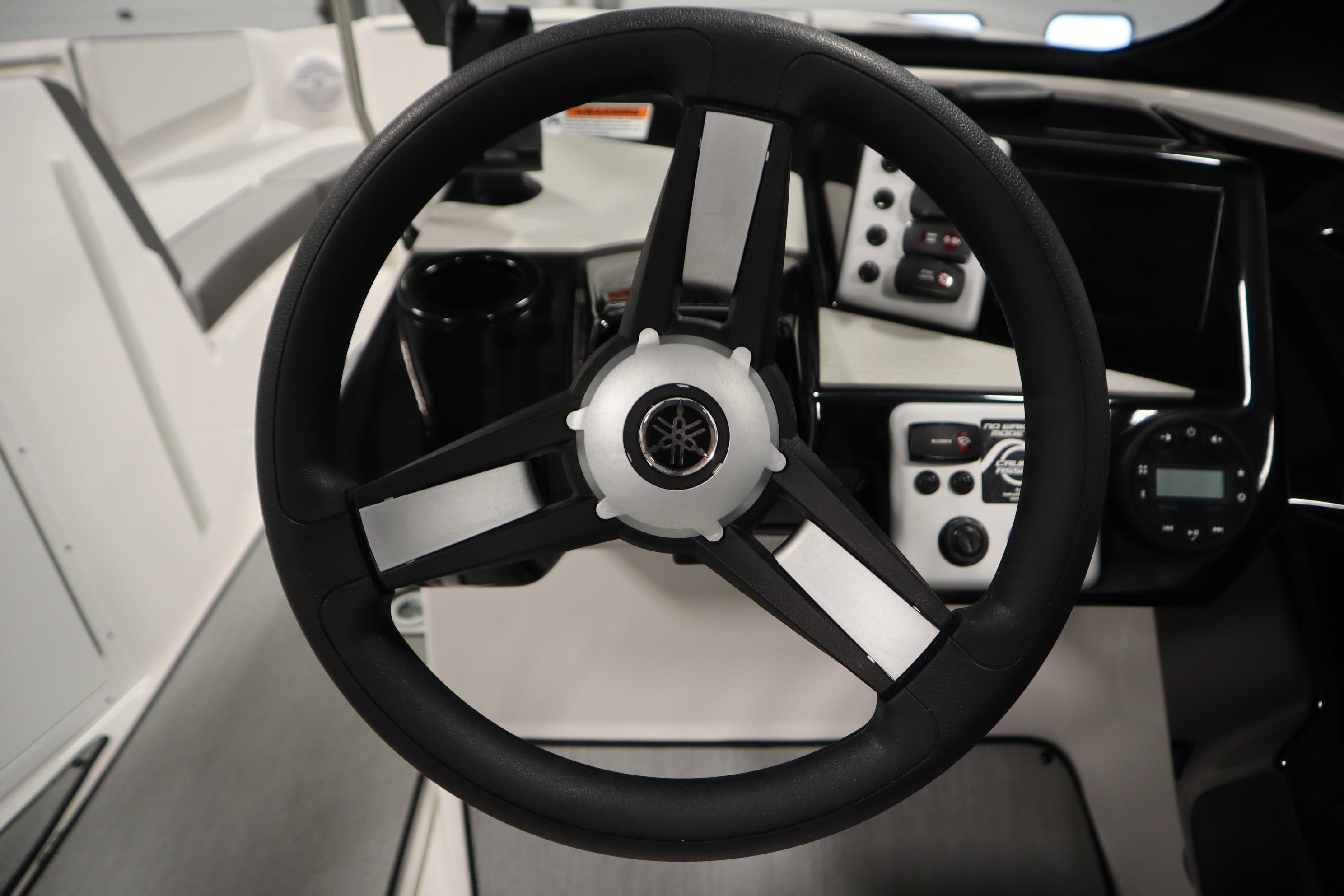 Steering wheel of 2026 Yamaha Boats AR220, featuring modern dashboard controls.