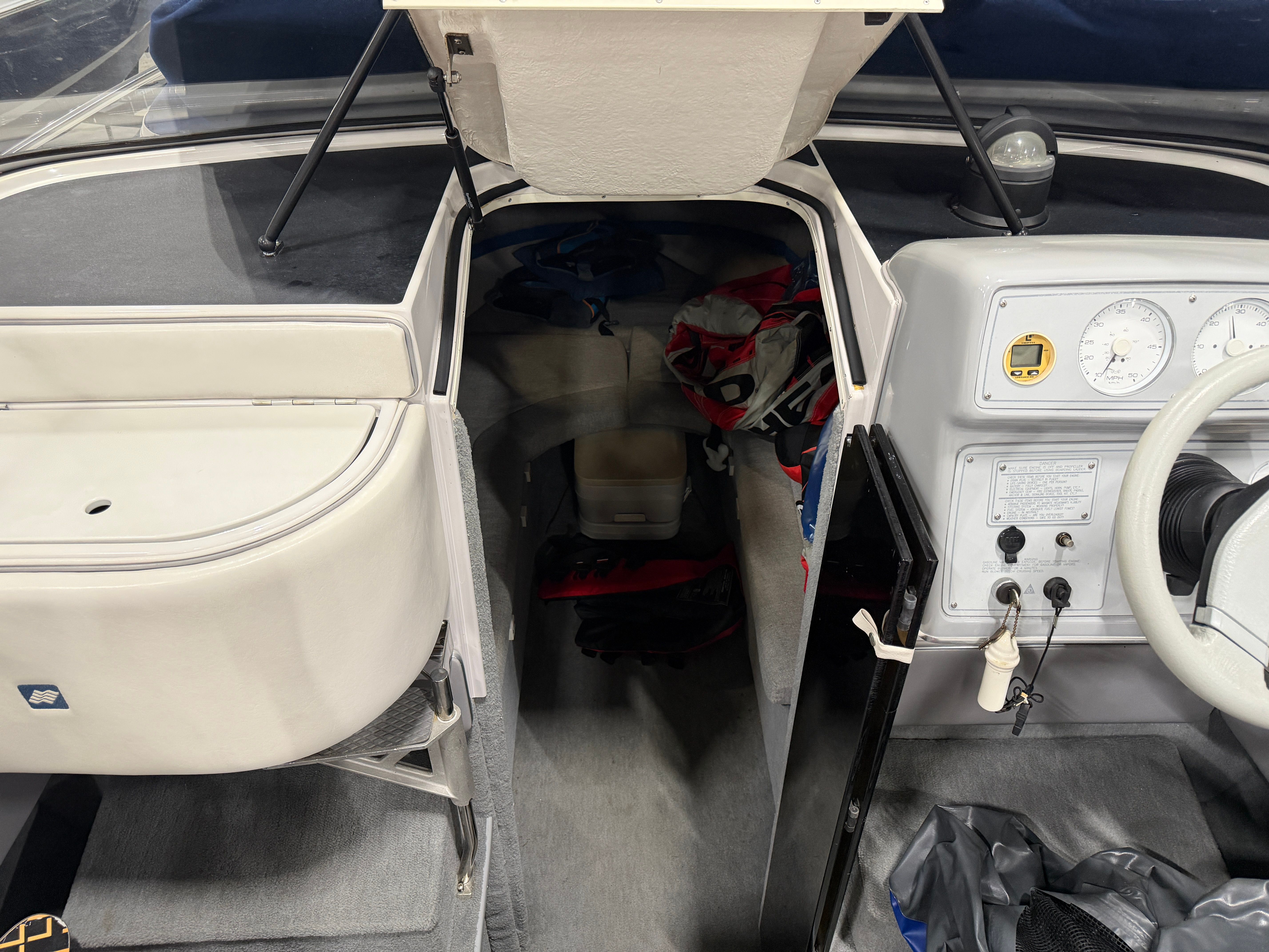 Interior view of a 1992 Four Winns 225 Sundowner with gray carpet and dashboard.