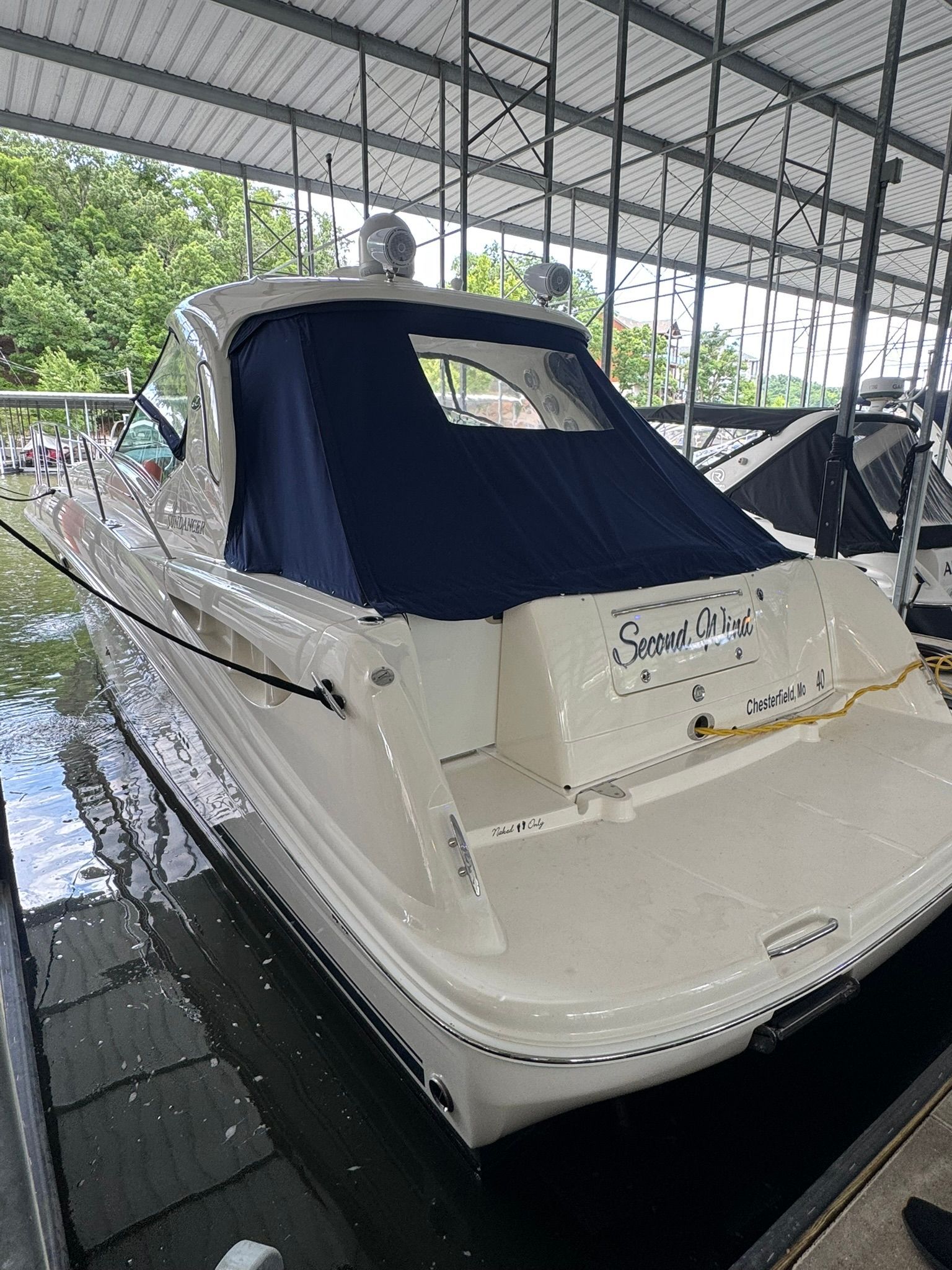 A 2007 Sea Ray 40 Sundancer is docked under a covered area.