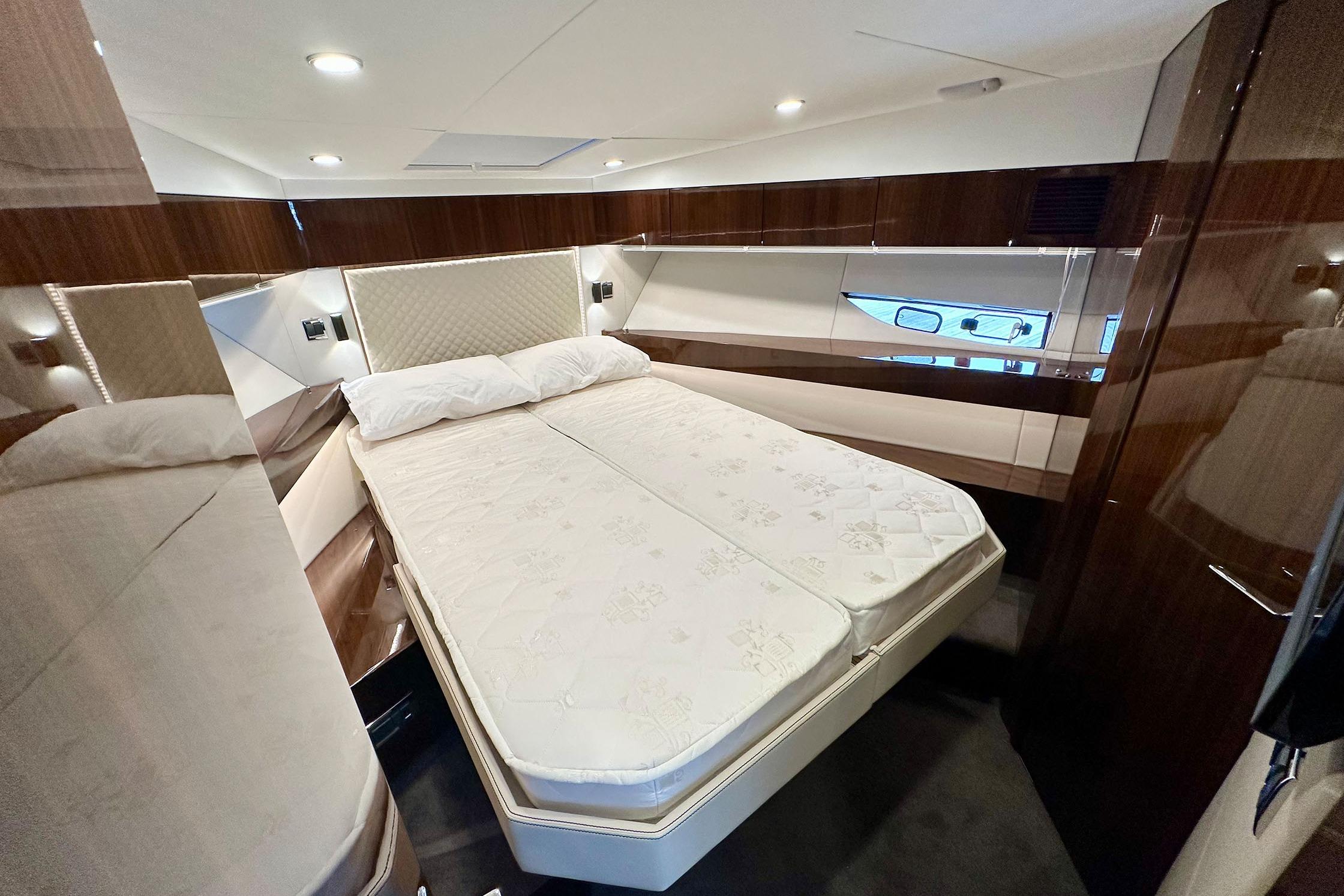 Luxurious bedroom interior of 2022 Fairline Targa 50 GT yacht with elegant wood finishes.